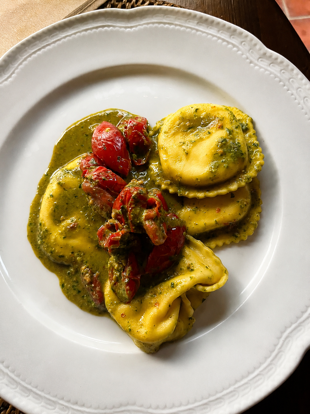 Homemade ravioli served with pesto, roasted tomatoes and herbs