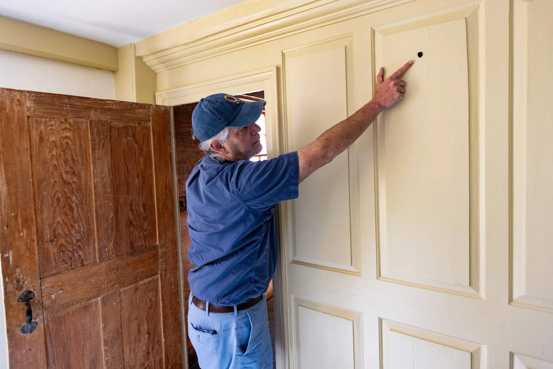 Joel Bohy pointing at a bullet strike in the Jason Russell House.