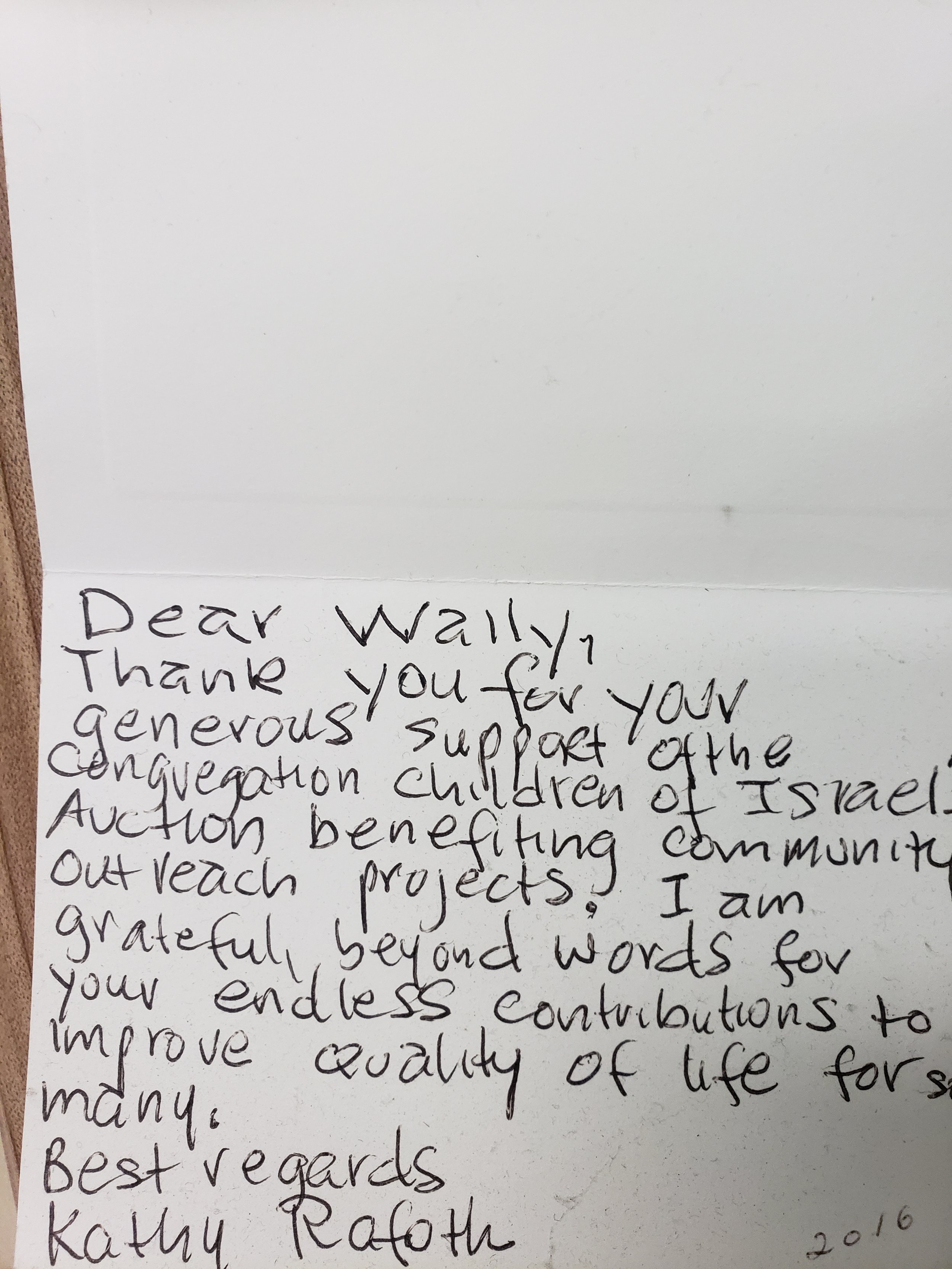 Handwritten thank you note on a piece of paper expressing gratitude for support of children's auction projects, signed by Kathy Raoth, dated 2016.
