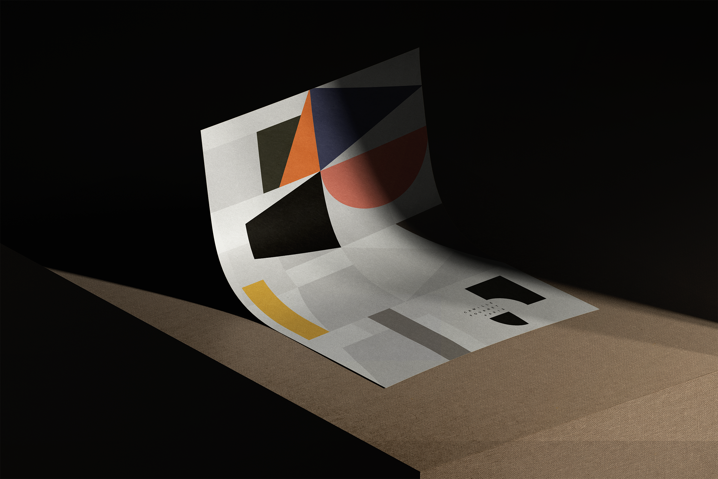 Une affiche d'art abstrait avec des formes géométriques colorées sur fond noir, posée sur une surface beige.