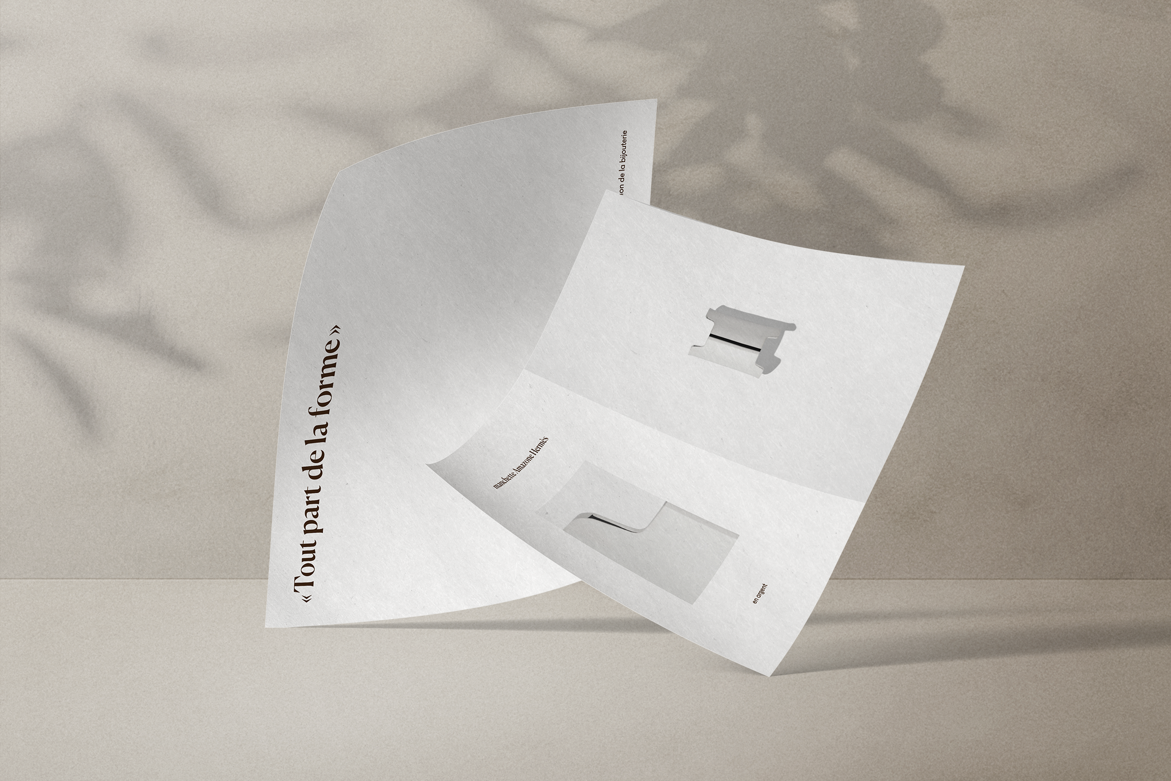Une brochure ouverte avec des images et du texte en français, placée sur une surface beige. La brochure présente des objets, probablement des outils ou des accessoires, avec un design minimaliste.