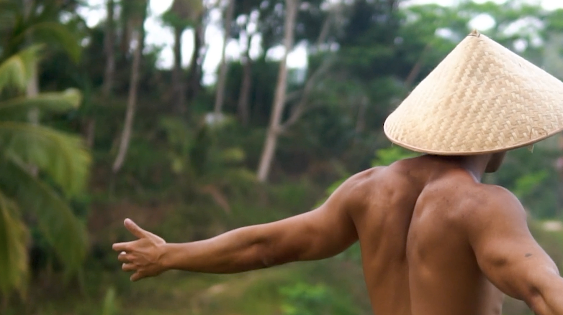 Person paddling a red kayak in clear, shallow water over rocks and coral