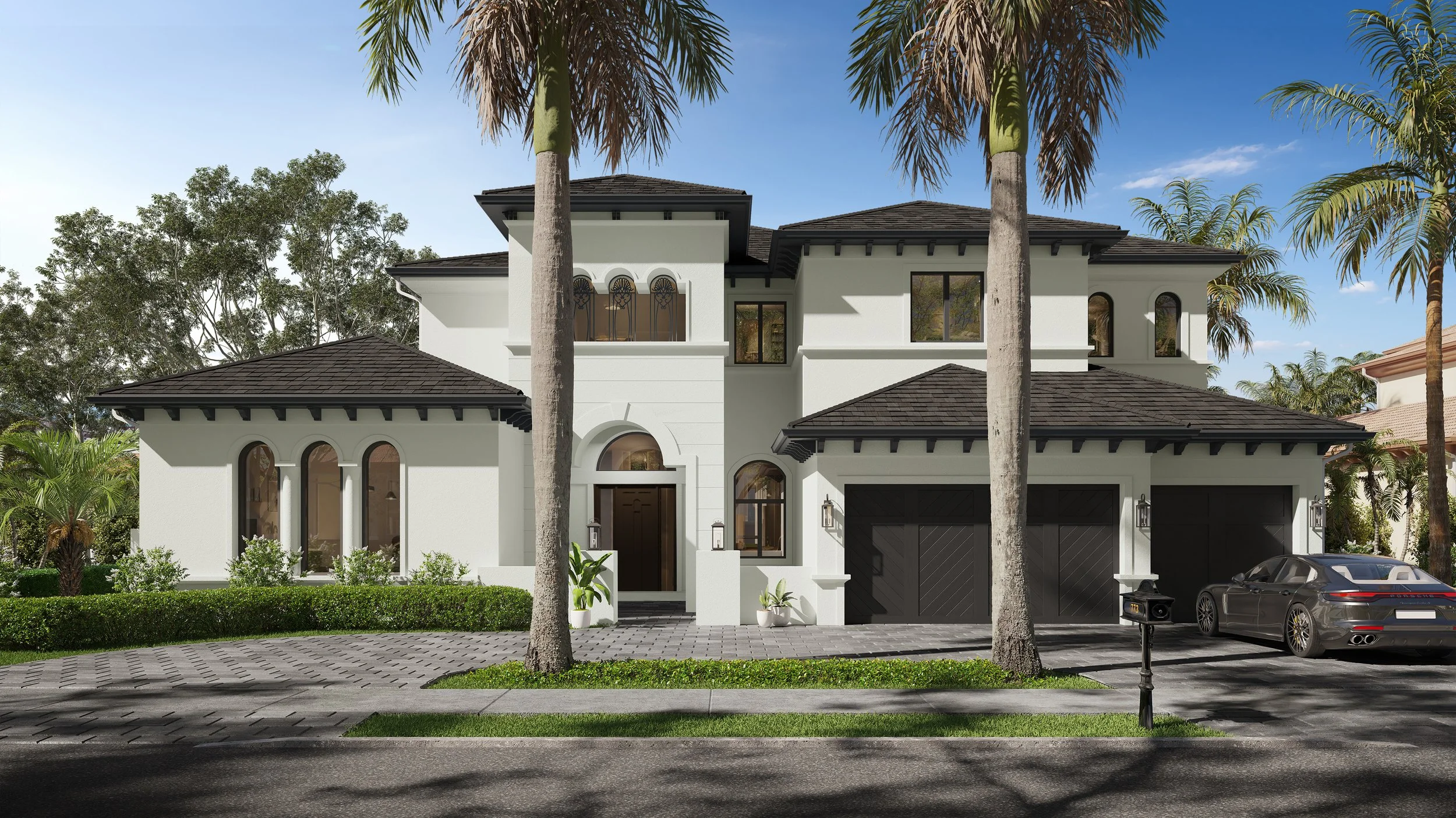Luxury custom home front view with grand arched entryway, large palm trees, and brick-paver driveway.