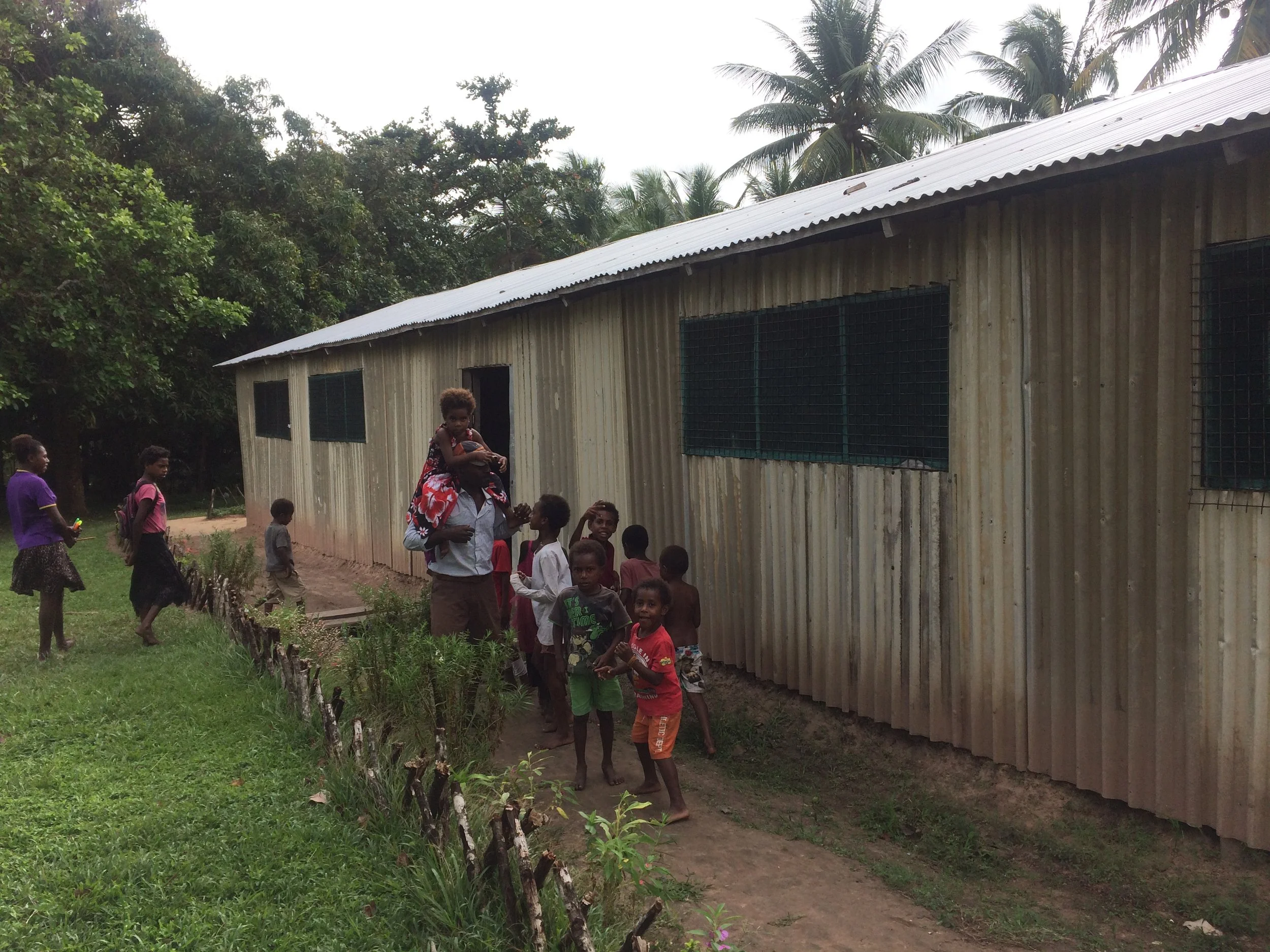 Mr Isaka Daru with students at the school