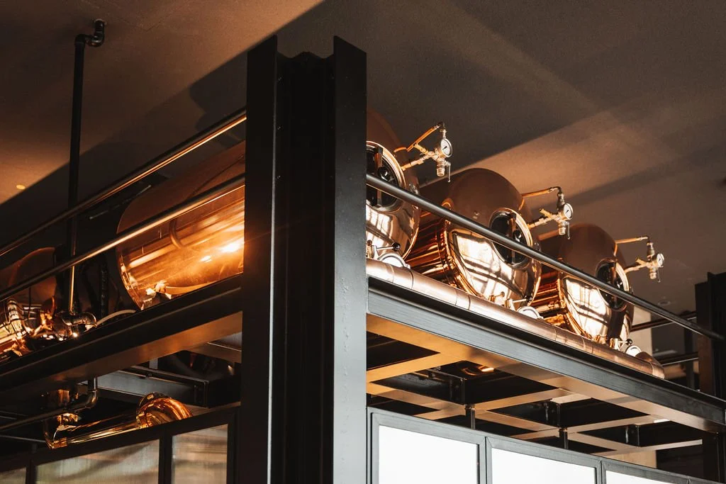 Industrial copper beer brewing tanks on a metal shelf in Wirtshaus Schwabinger Tor Bräu.