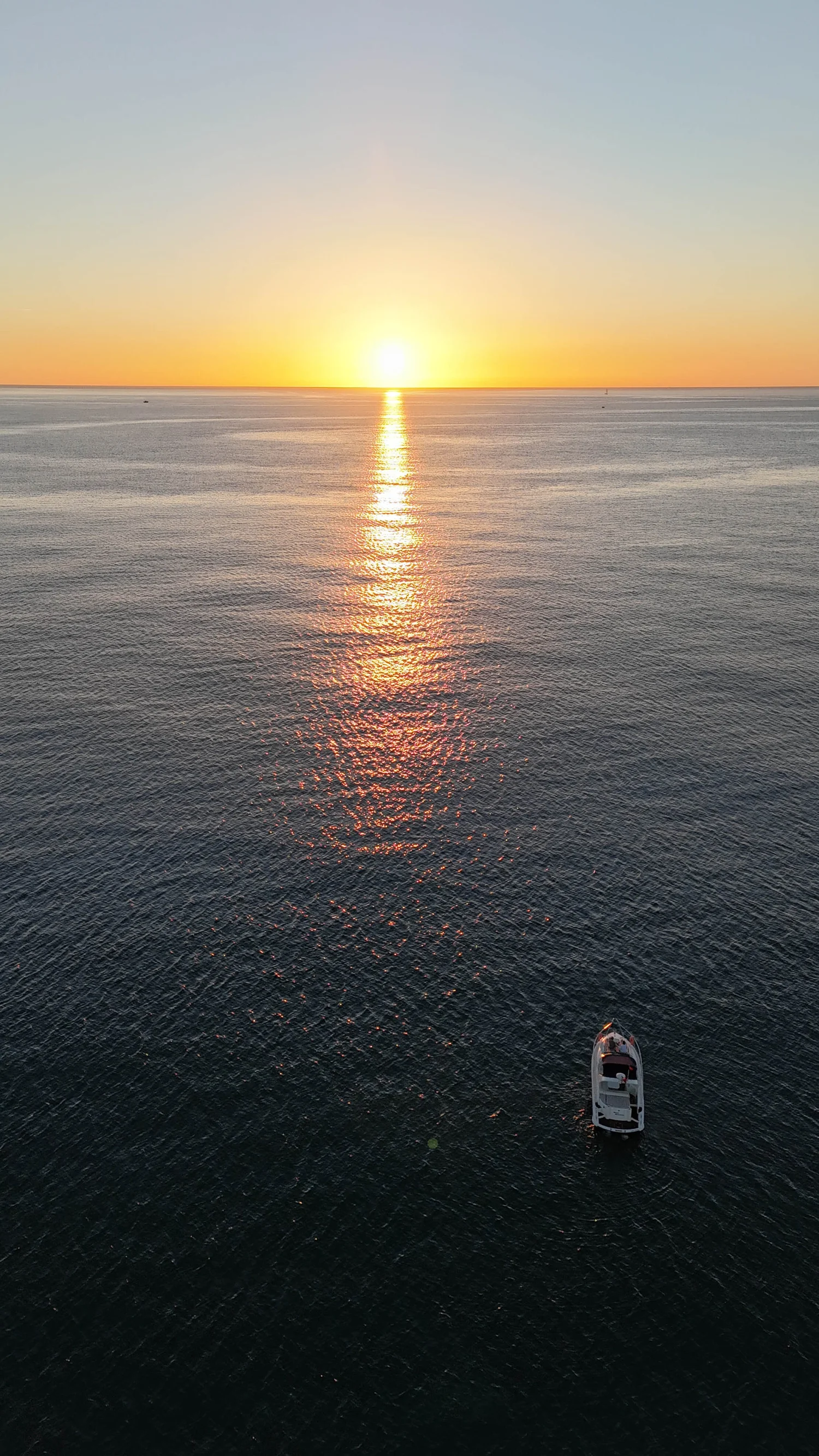 Boat on calm ocean water at sunrise