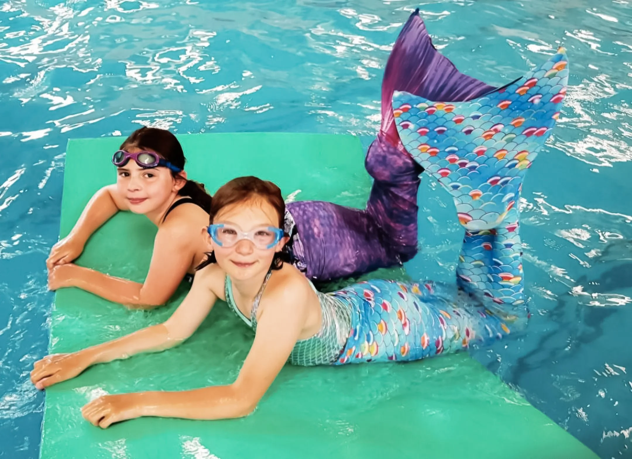 Group of children wearing mermaid tails posing for photos at a Dorset swim party