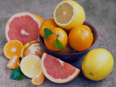 Assortiment de fruits, notamment citrons, oranges, pamplemousses, et mandarines, certains tranchés et d'autres entiers, sur une surface