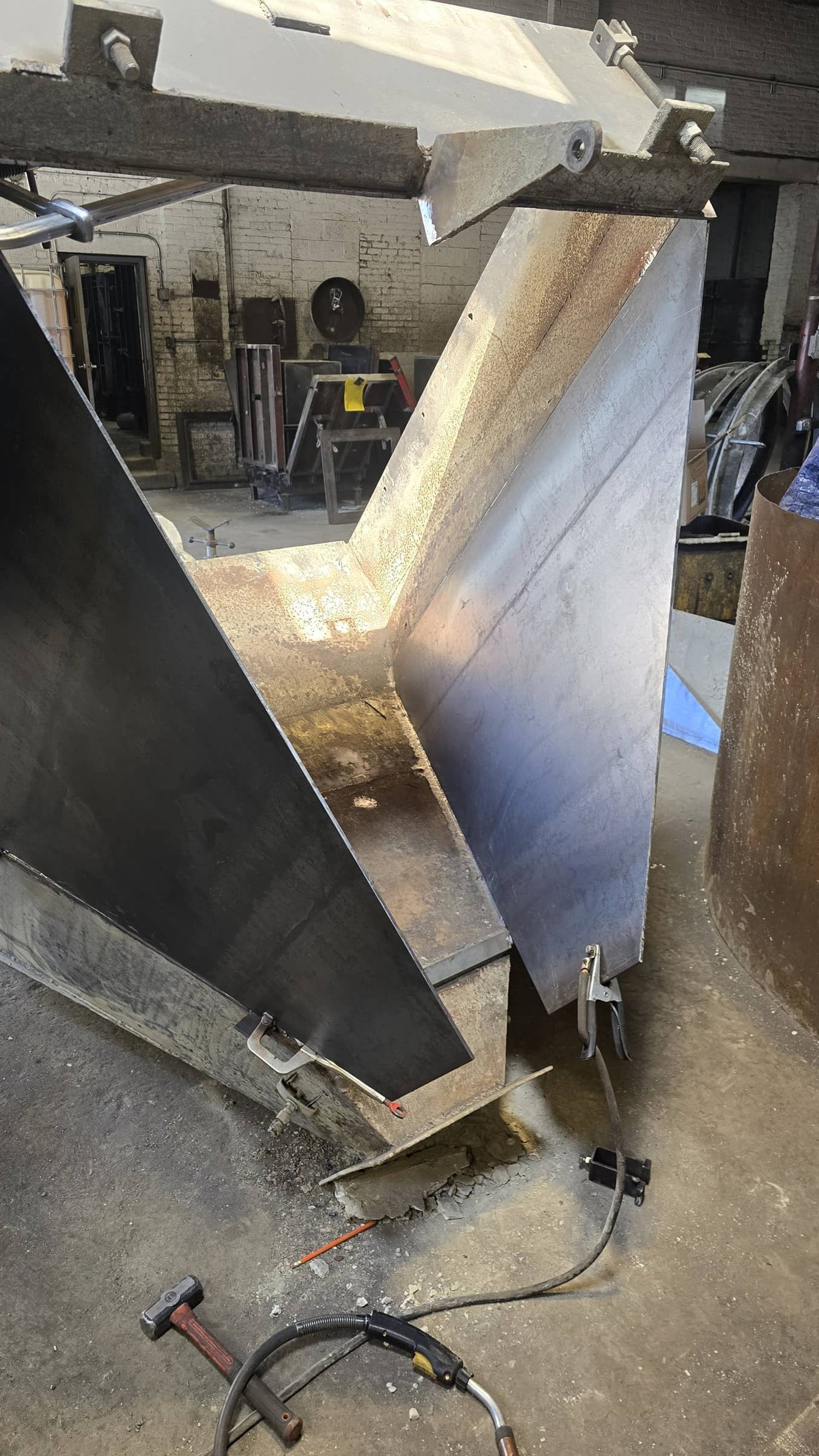 Industrial metal workpiece being welded or assembled in a workshop.
