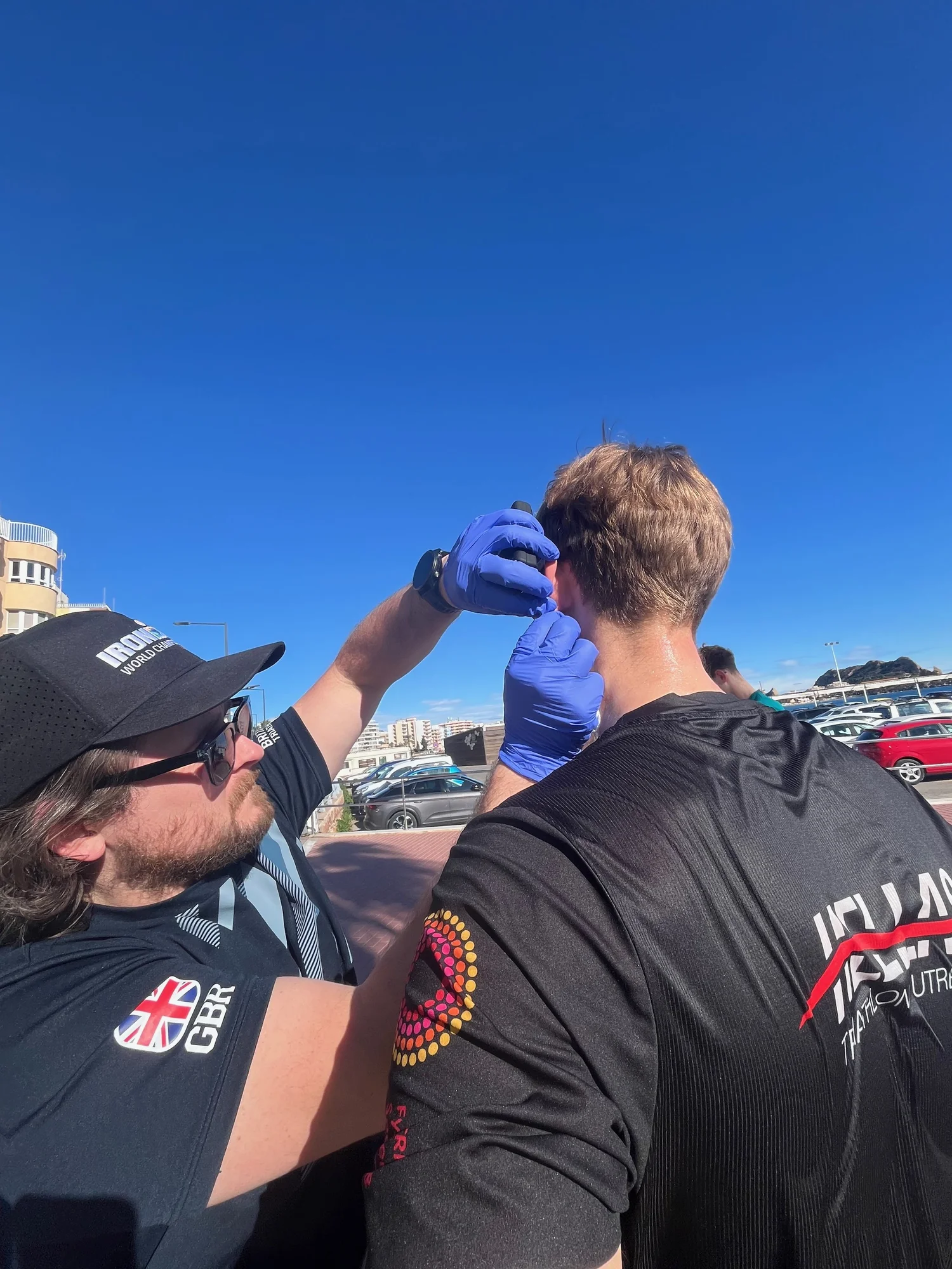 Coach taking a finger-prick sample from an athlete during outdoor field testing
