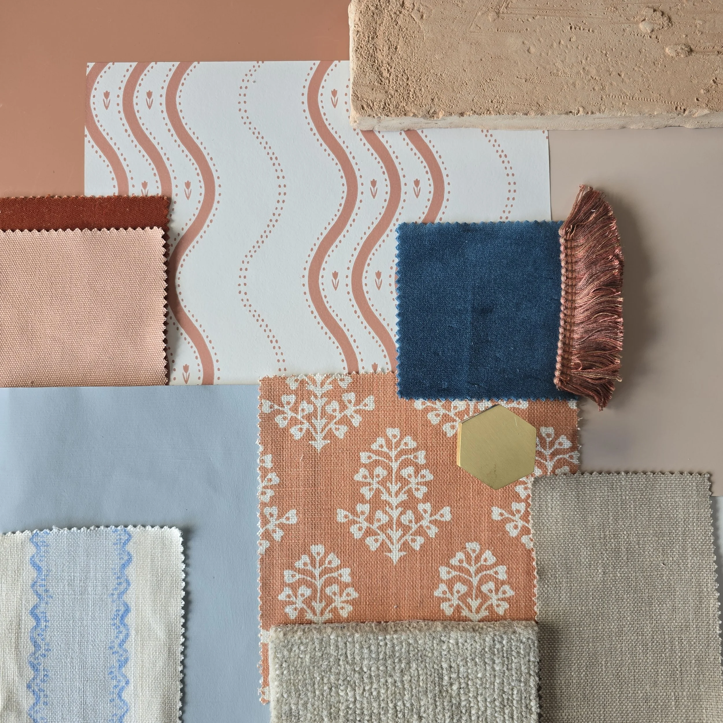 Mood board showing assorted fabric swatches with various textures and patterns, including floral and wavy designs, in colors like blue, peach, and beige, and terracotta.