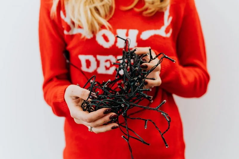 a person holding tangled Christmas lights