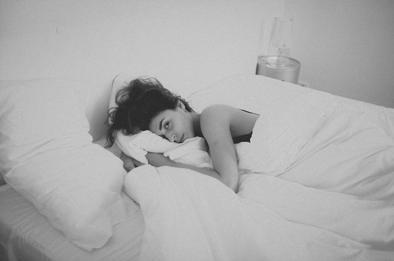 A black and white image of a woman in bed