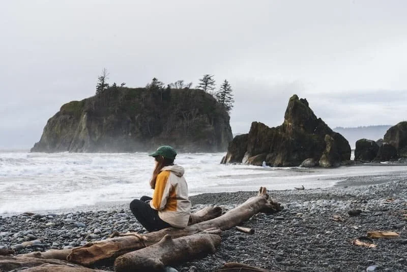A woman sitting alone on the coast