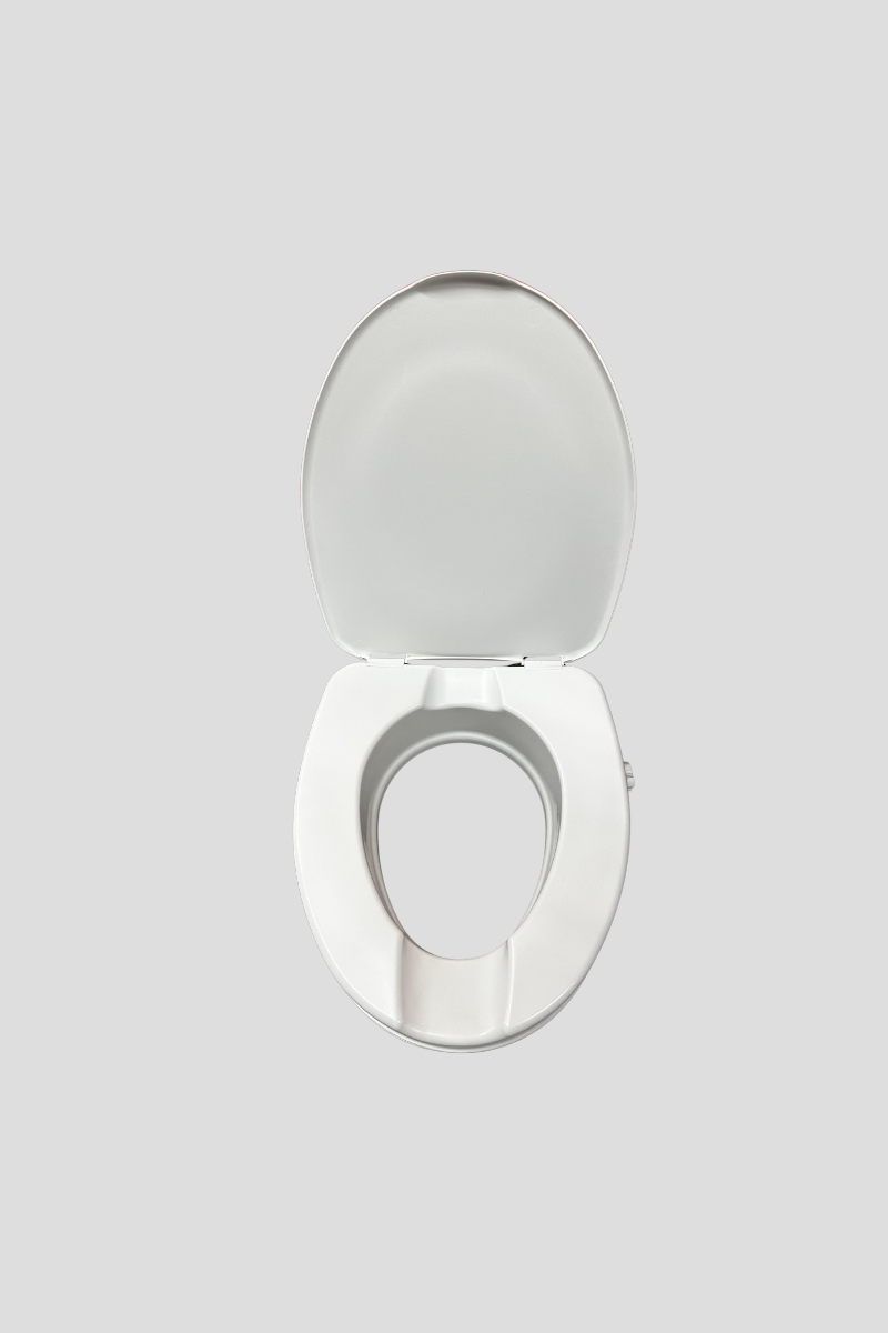 A white toilet with an open lid in front of a red storage unit with horizontal grooves, on a multicolored carpeted floor.