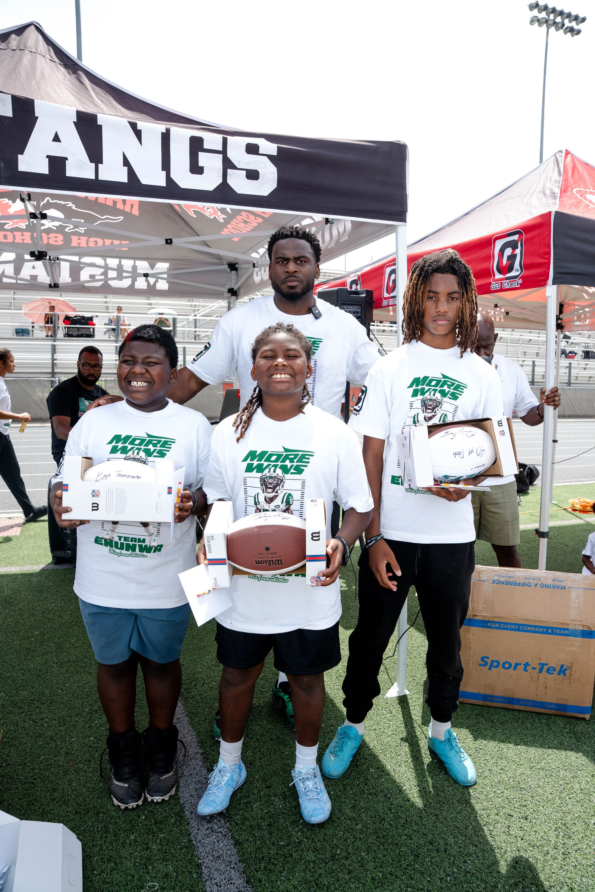 Campers standing with New York Jets prize footballs signed by Quincy Enunwa 