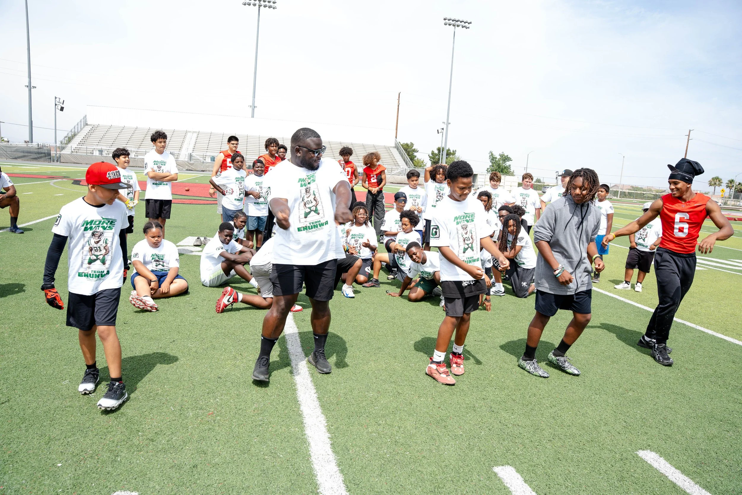 Campers dancing and enjoying their time with a coach and Rancho Verde Football player