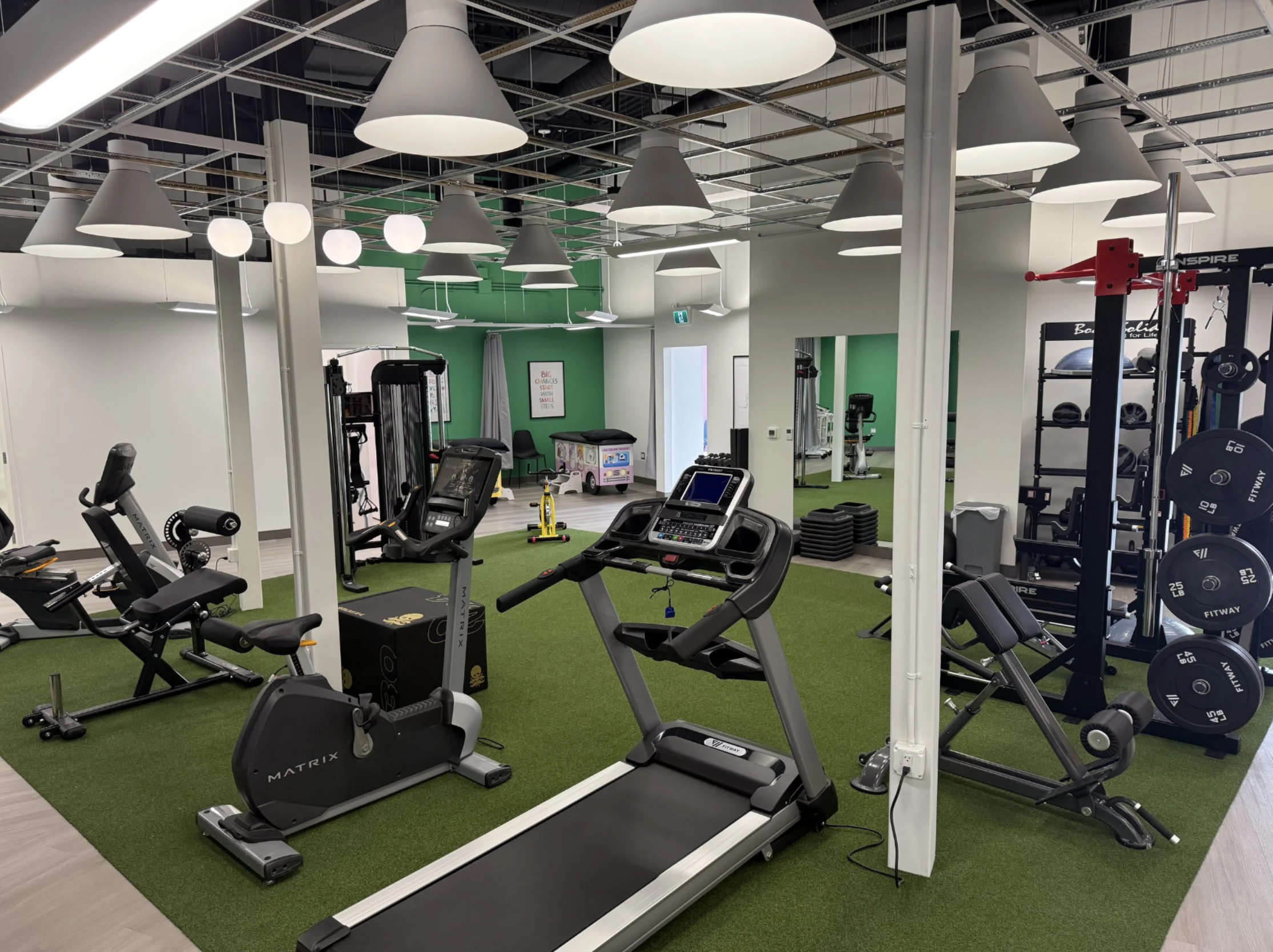 Rehab gym with cardio and strength equipment on turf flooring