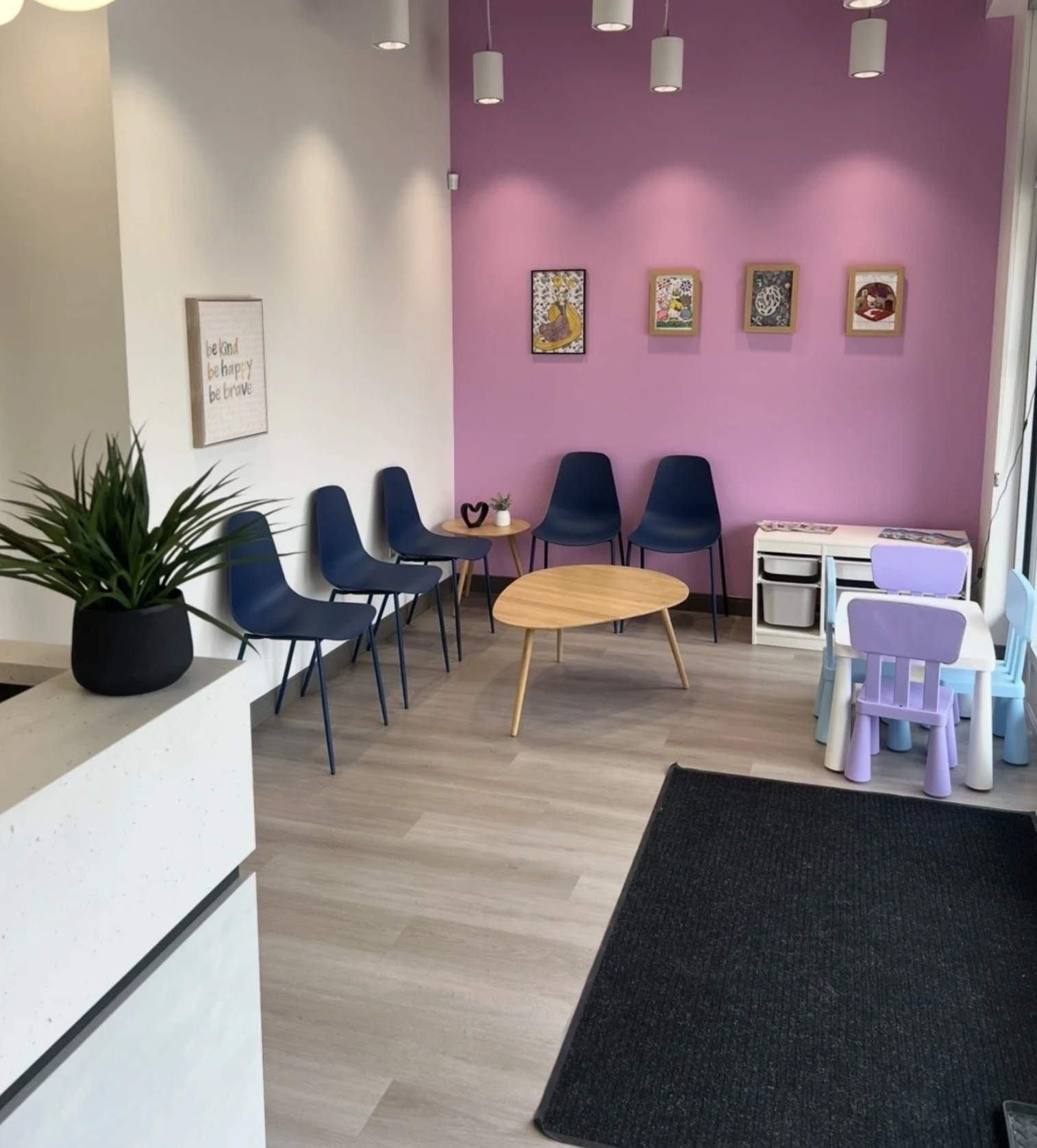 Waiting area with pink accent wall and family seating