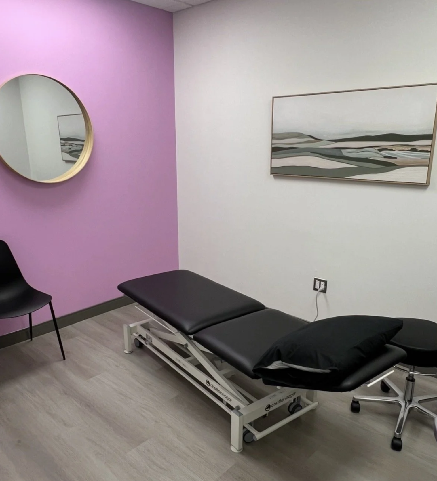 Treatment room with pink accent wall and treatment table