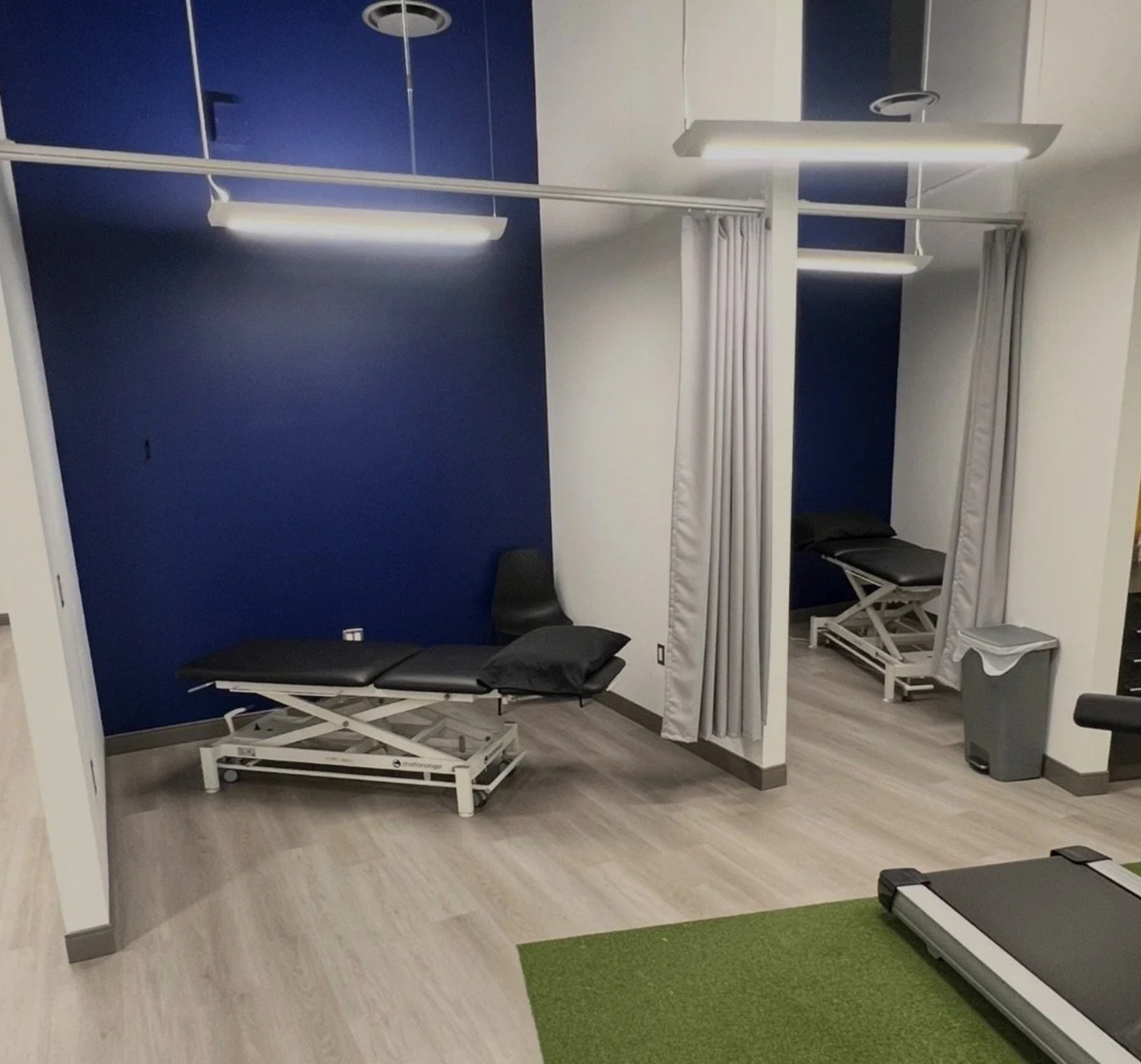 Private treatment bays with curtains, treatment tables and turf training strip
