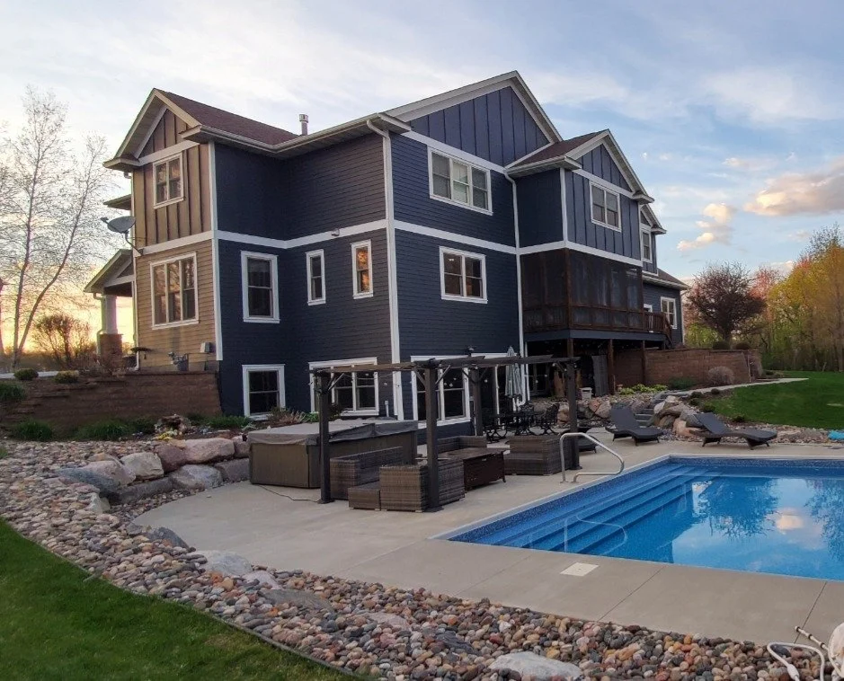 Plymouth exterior transformation featuring a bold dark blue upgrade with crisp white trim and stone accents.