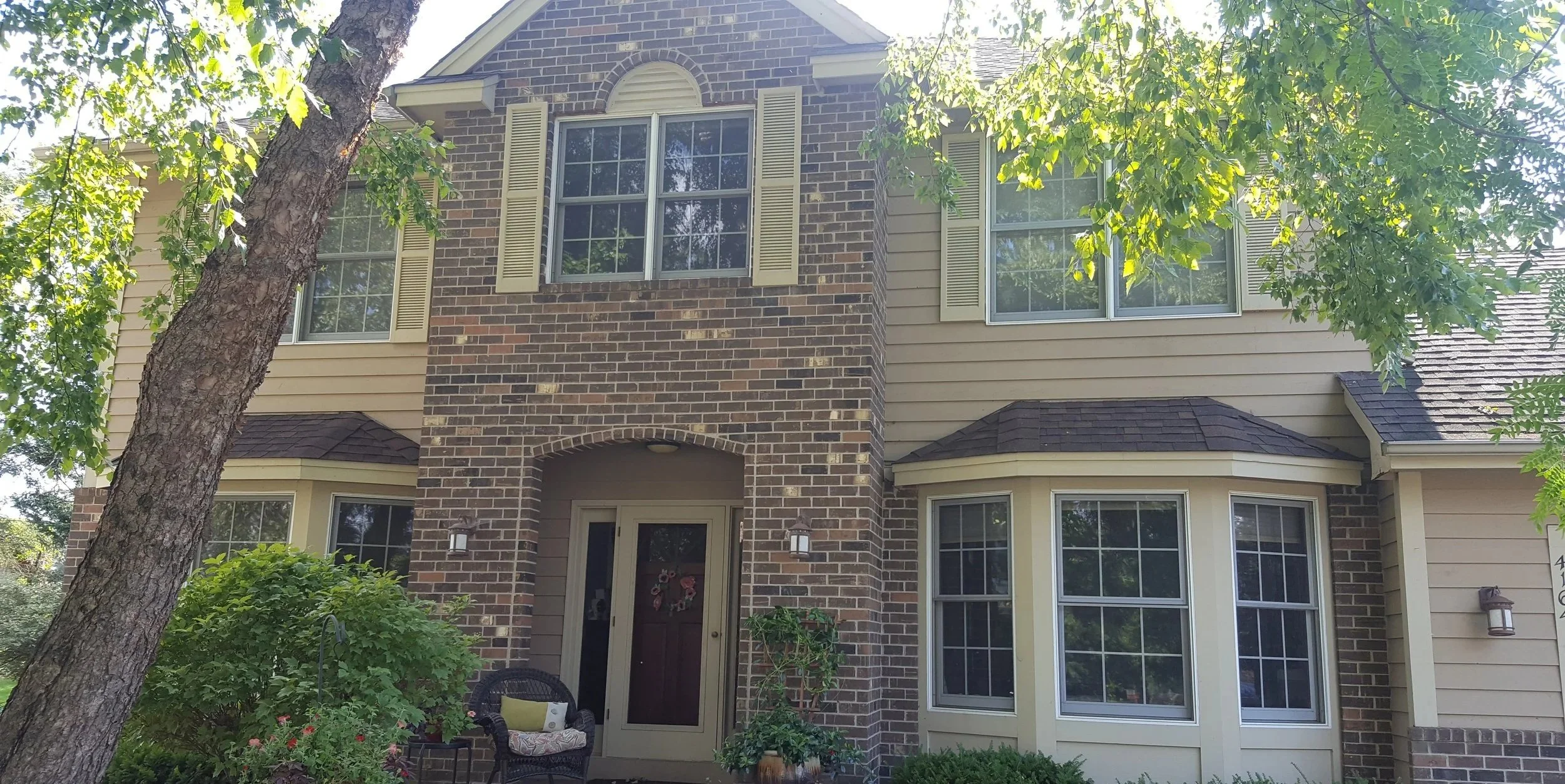 Classic brick and siding exterior repaint on a traditional two-story home in Eagan