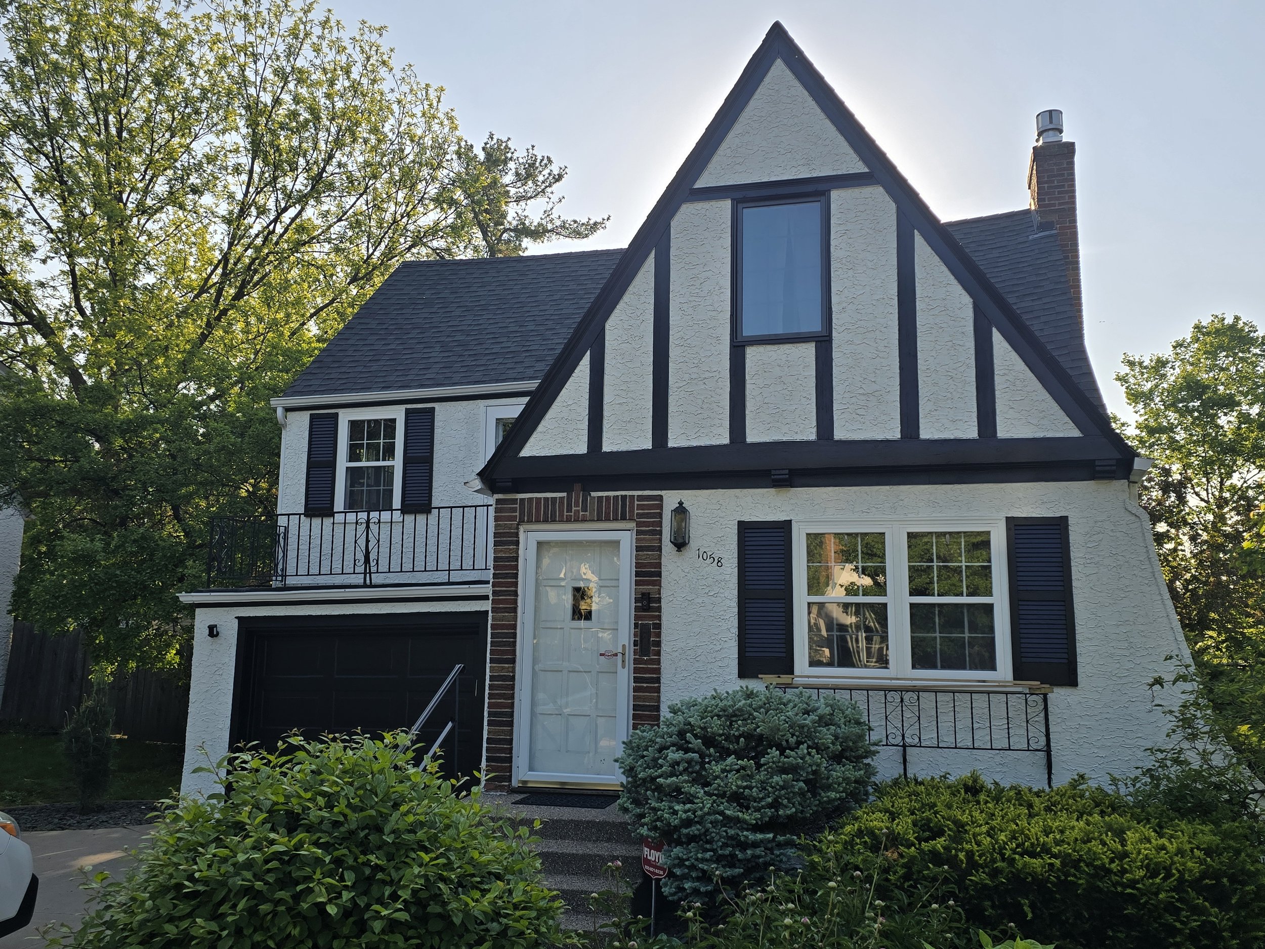 Freshly painted Tudor-style home in Minneapolis with white stucco and dark trim.