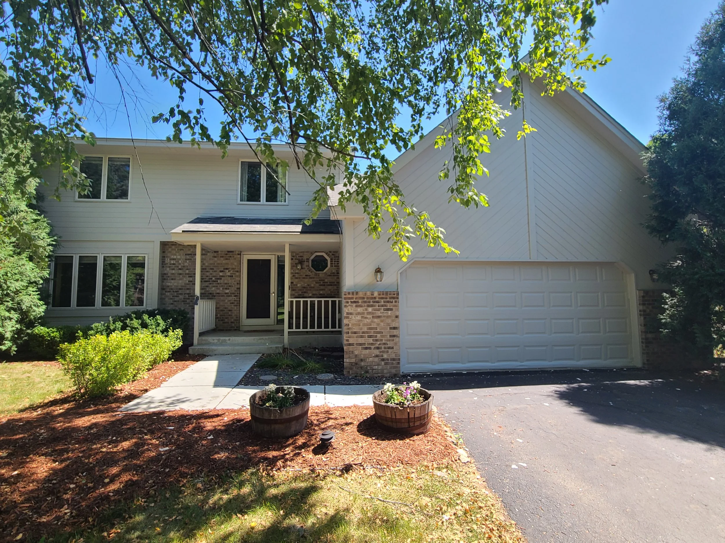 White siding and brick split-level home after exterior painting in Bloomington MN
