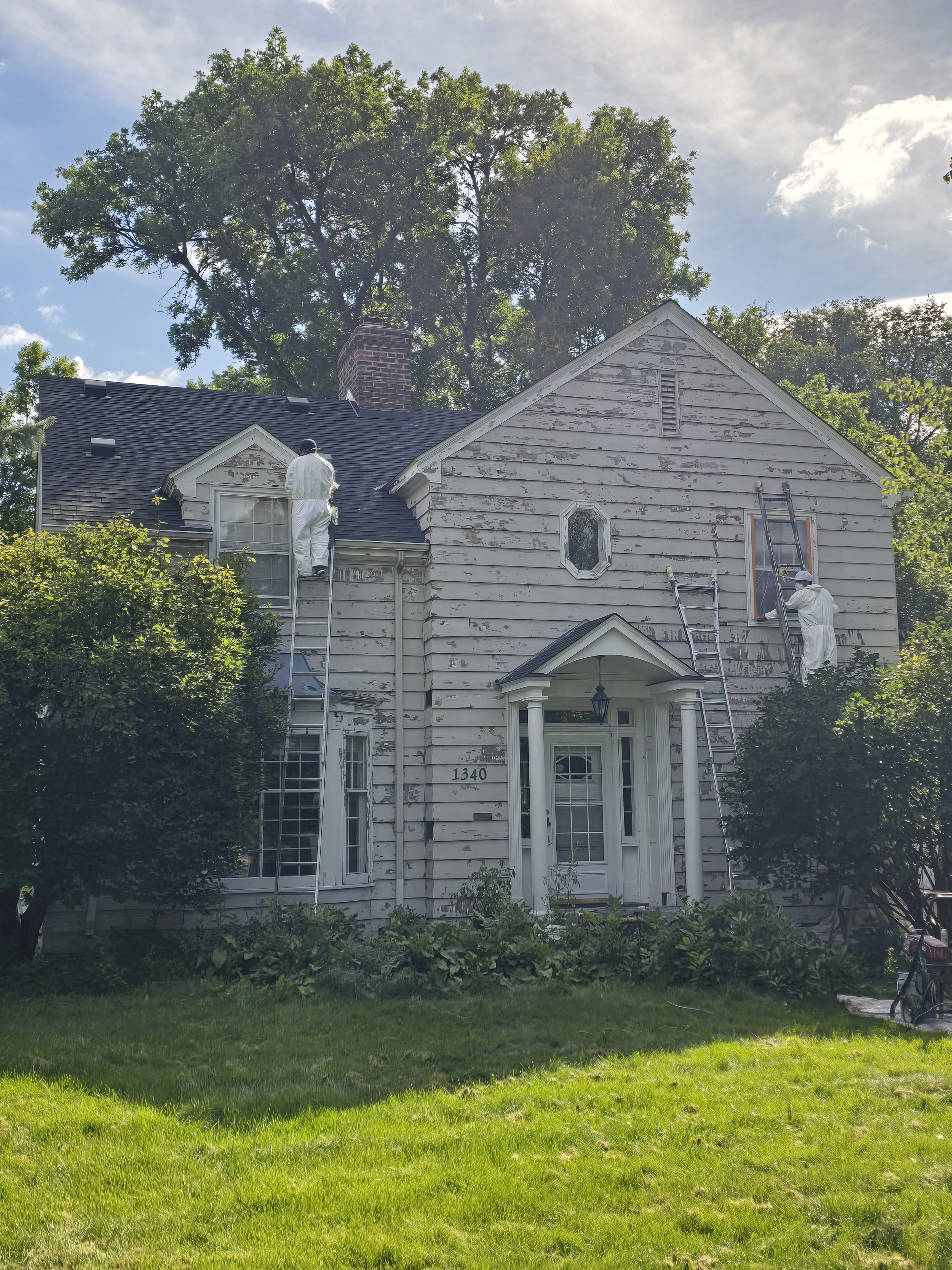 Careful hand scraping on a historic Highland Park home before its exterior transformation.