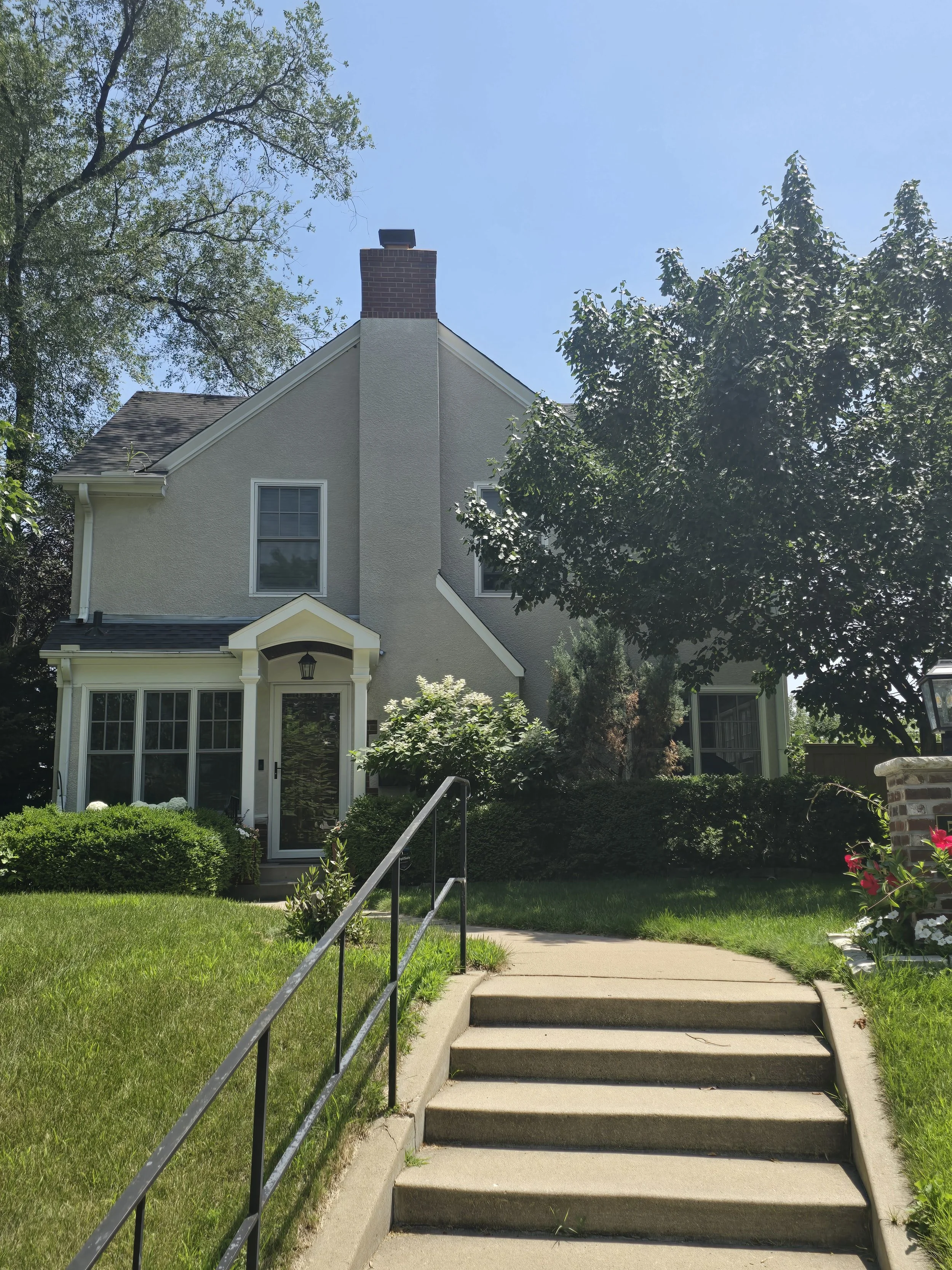 Highland Park exterior repaint in Saint Paul featuring warm stucco tones with bold dark trim for a clean, timeless finish