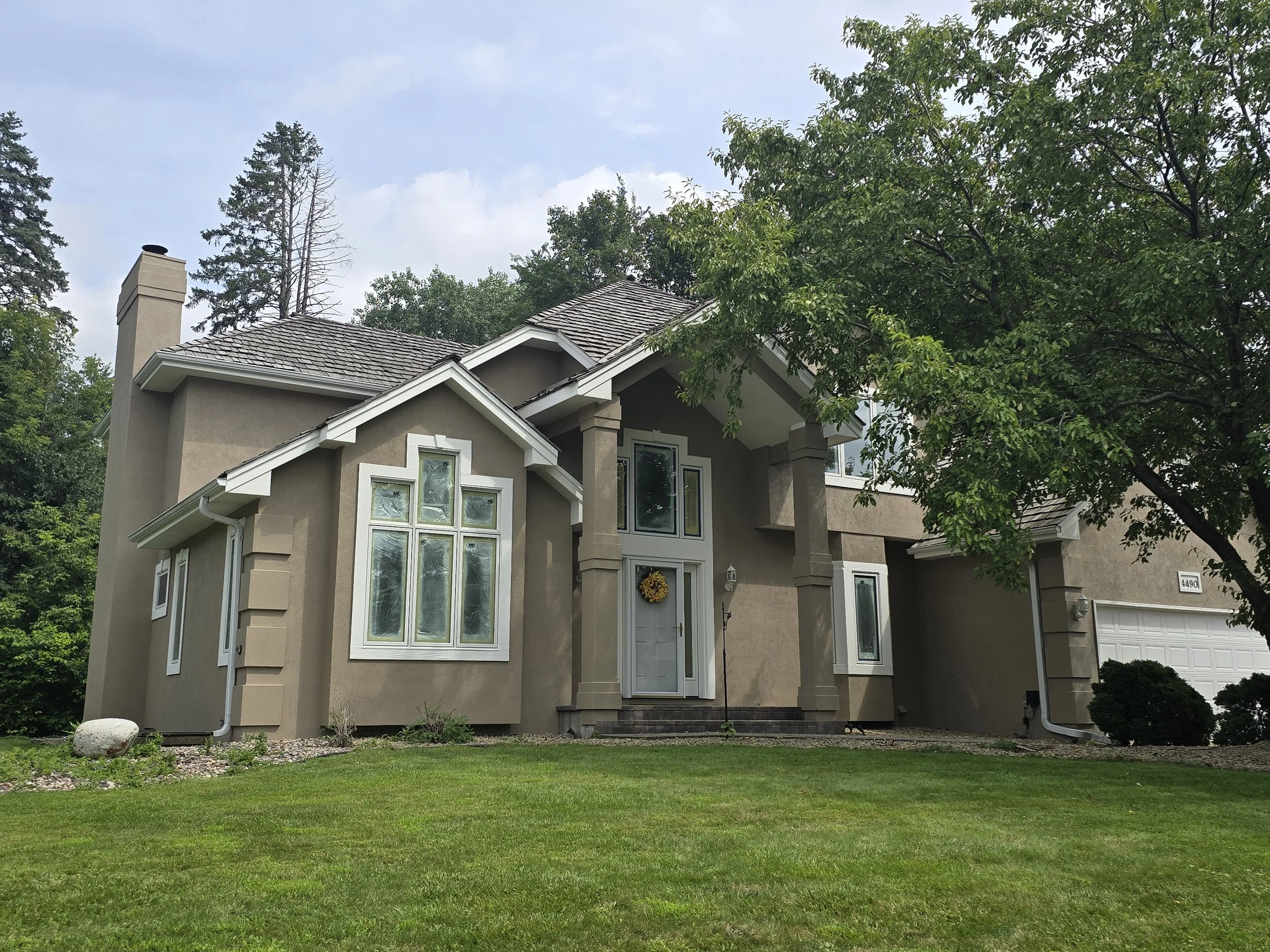 Clean, modern exterior repaint on a custom Plymouth stucco home