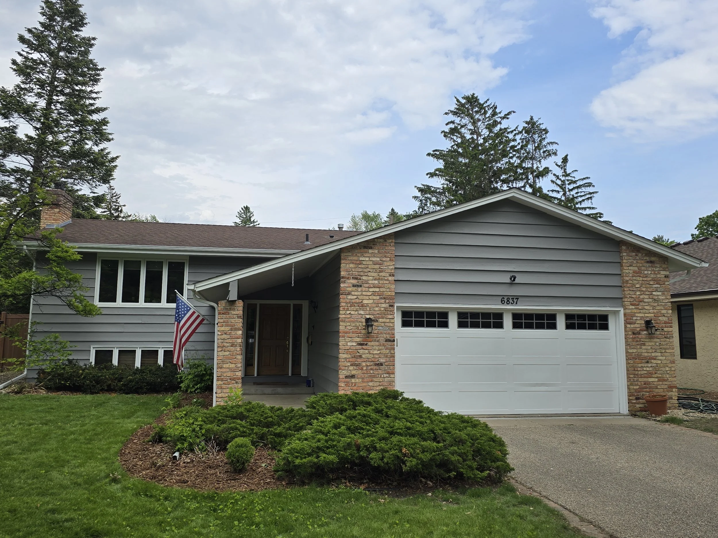 Fresh exterior repaint on a classic Bloomington split-level (SW Mindful Gray) with brick and siding