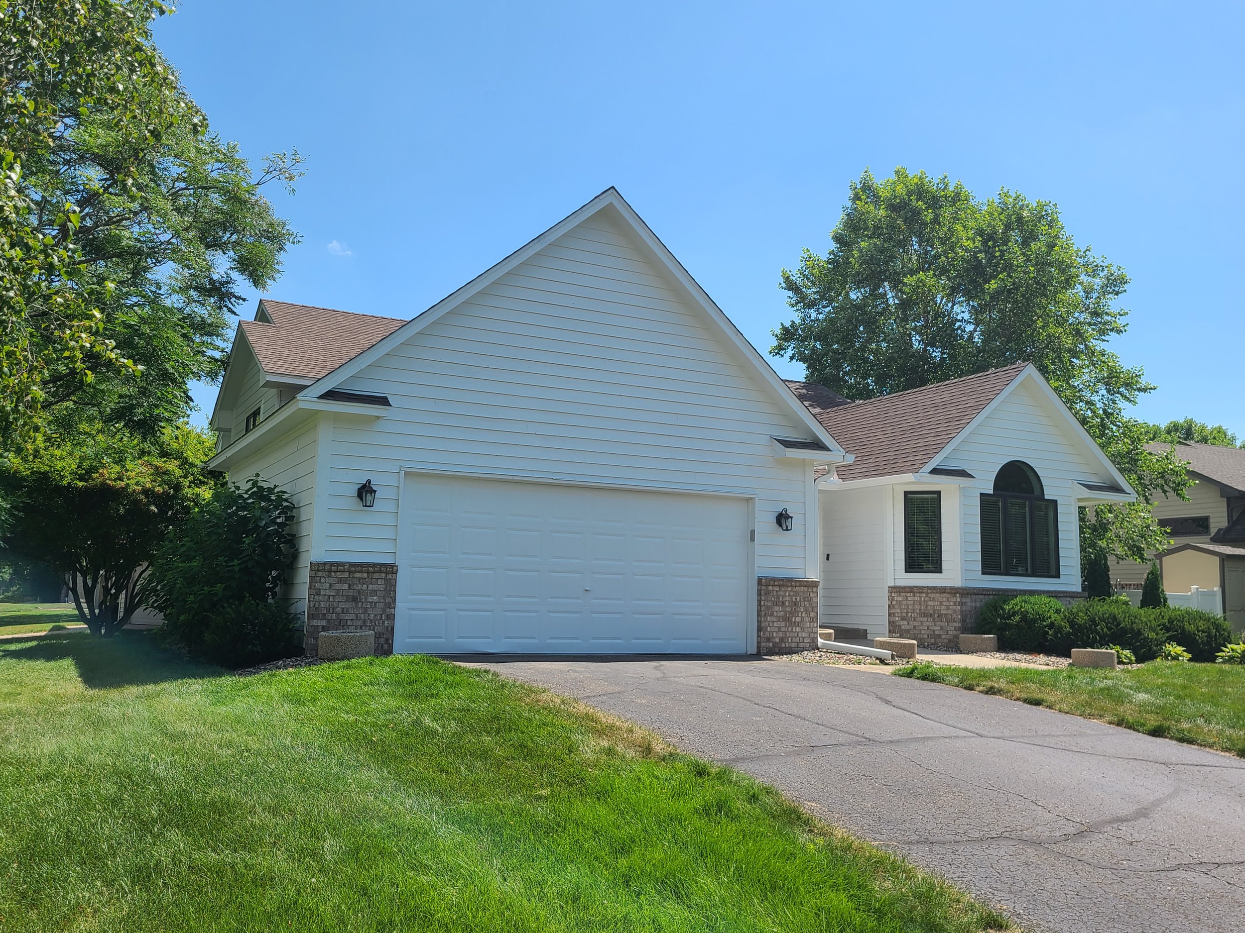 Fresh white exterior repaint on a bright suburban home in Eagan