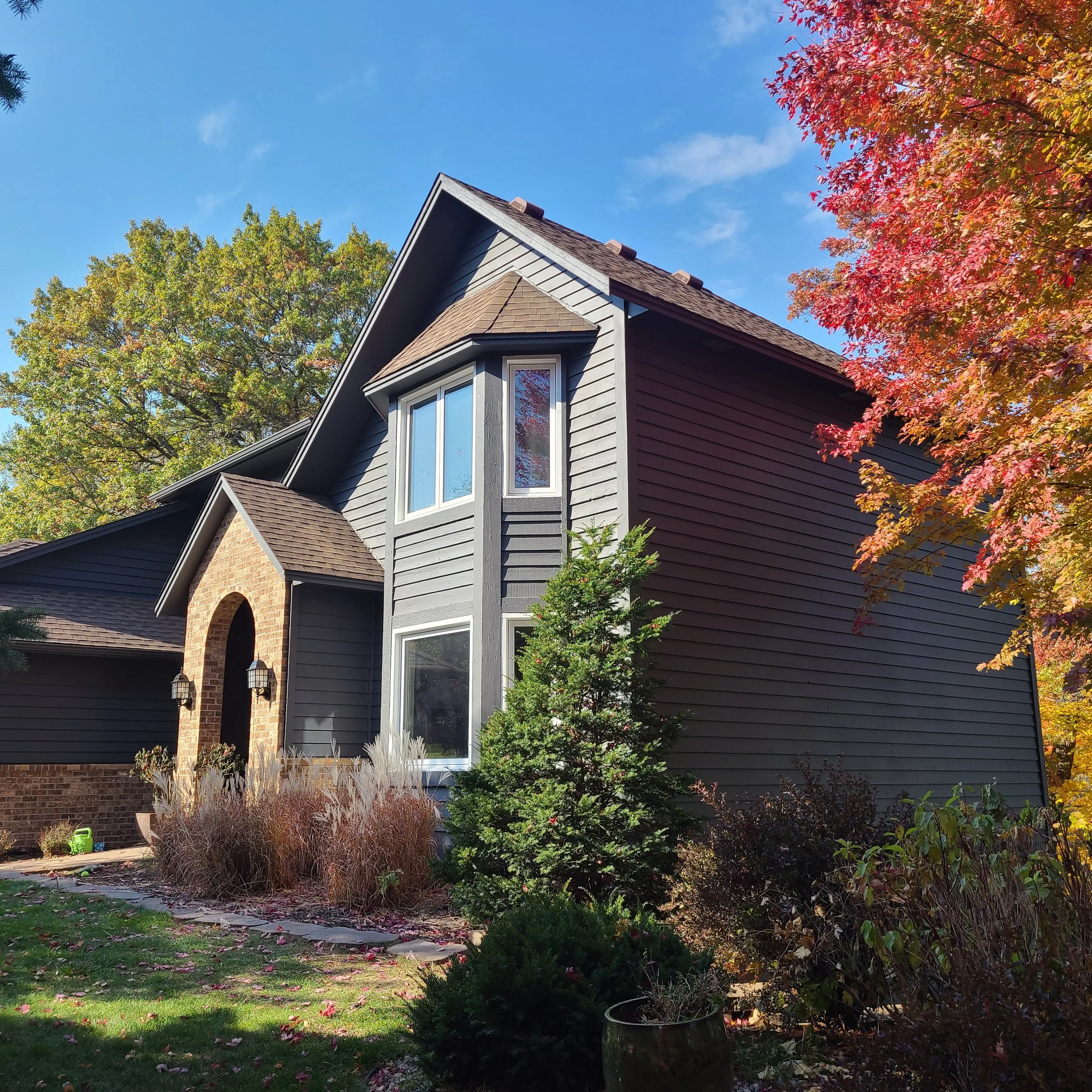 Modern exterior repaint on a two-story Eagan home featuring an arched front entry and updated trim