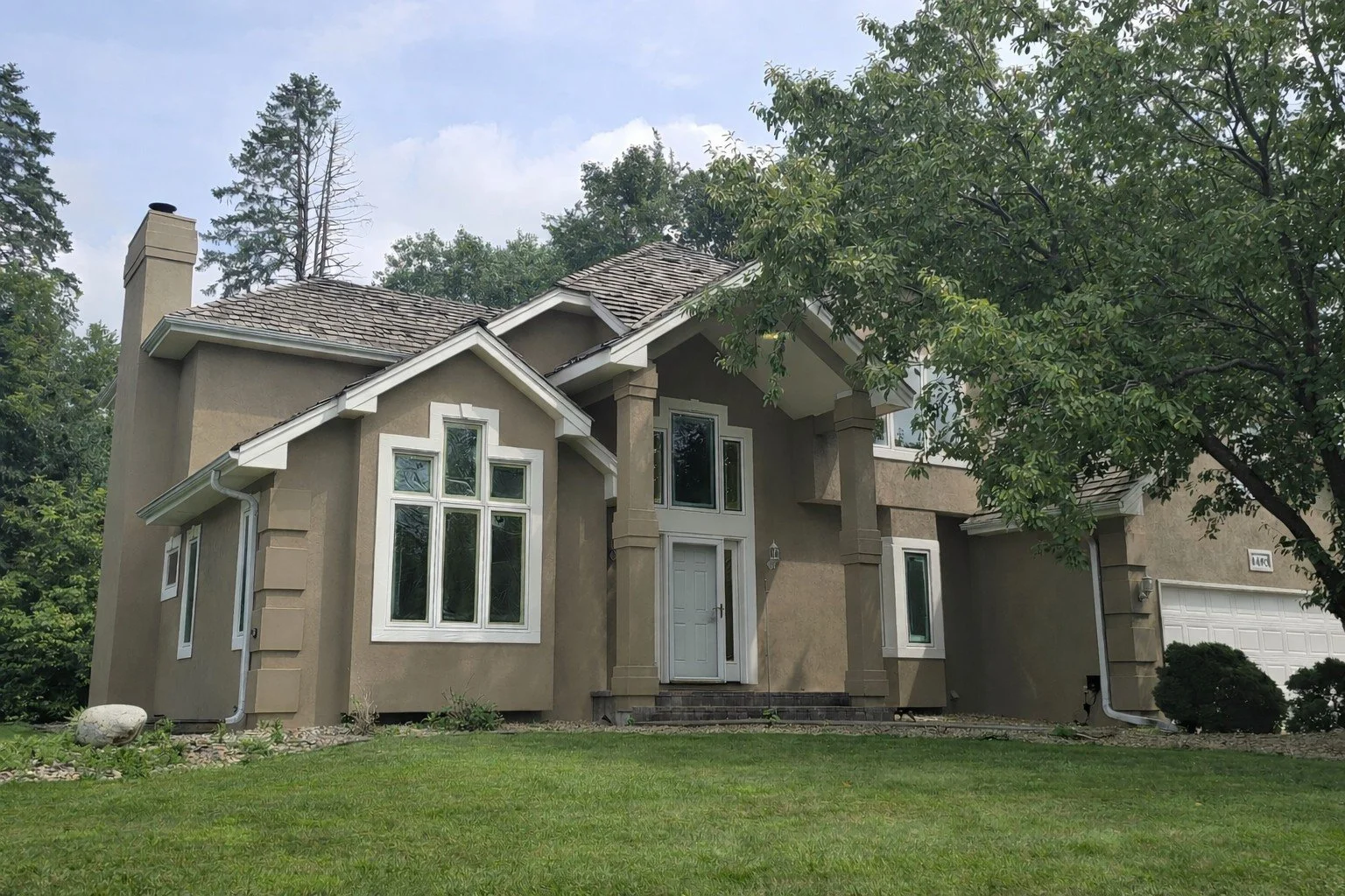 Plymouth stucco exterior refresh with updated neutral tones and crisp white trim for a clean, modern finish.