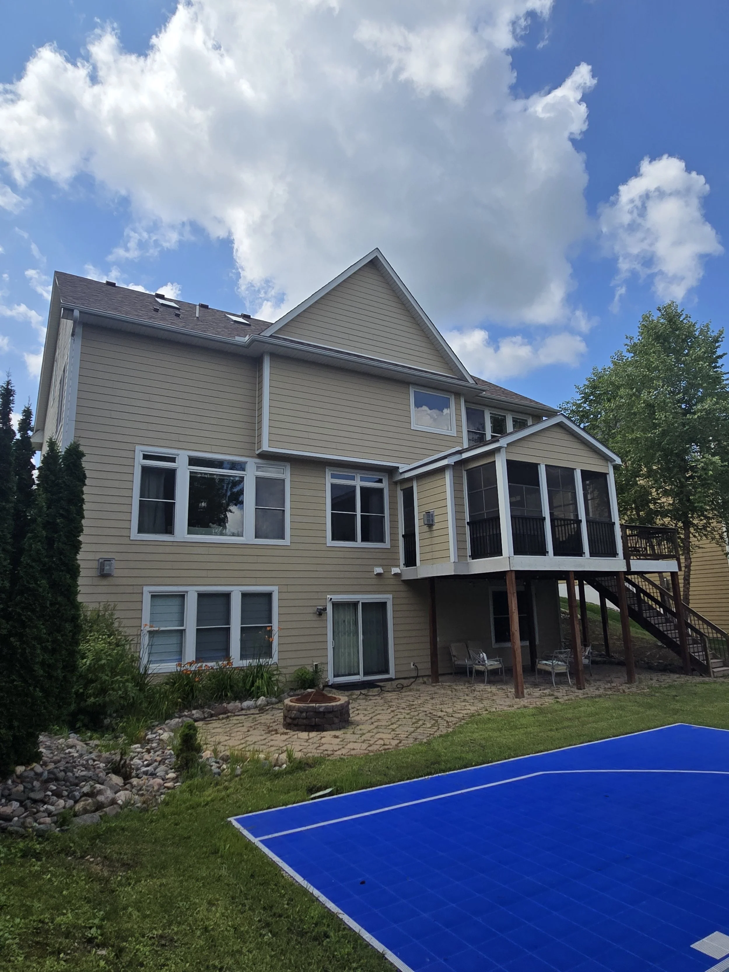 Warm beige exterior repaint with refreshed siding and screened porch on this Bloomington home