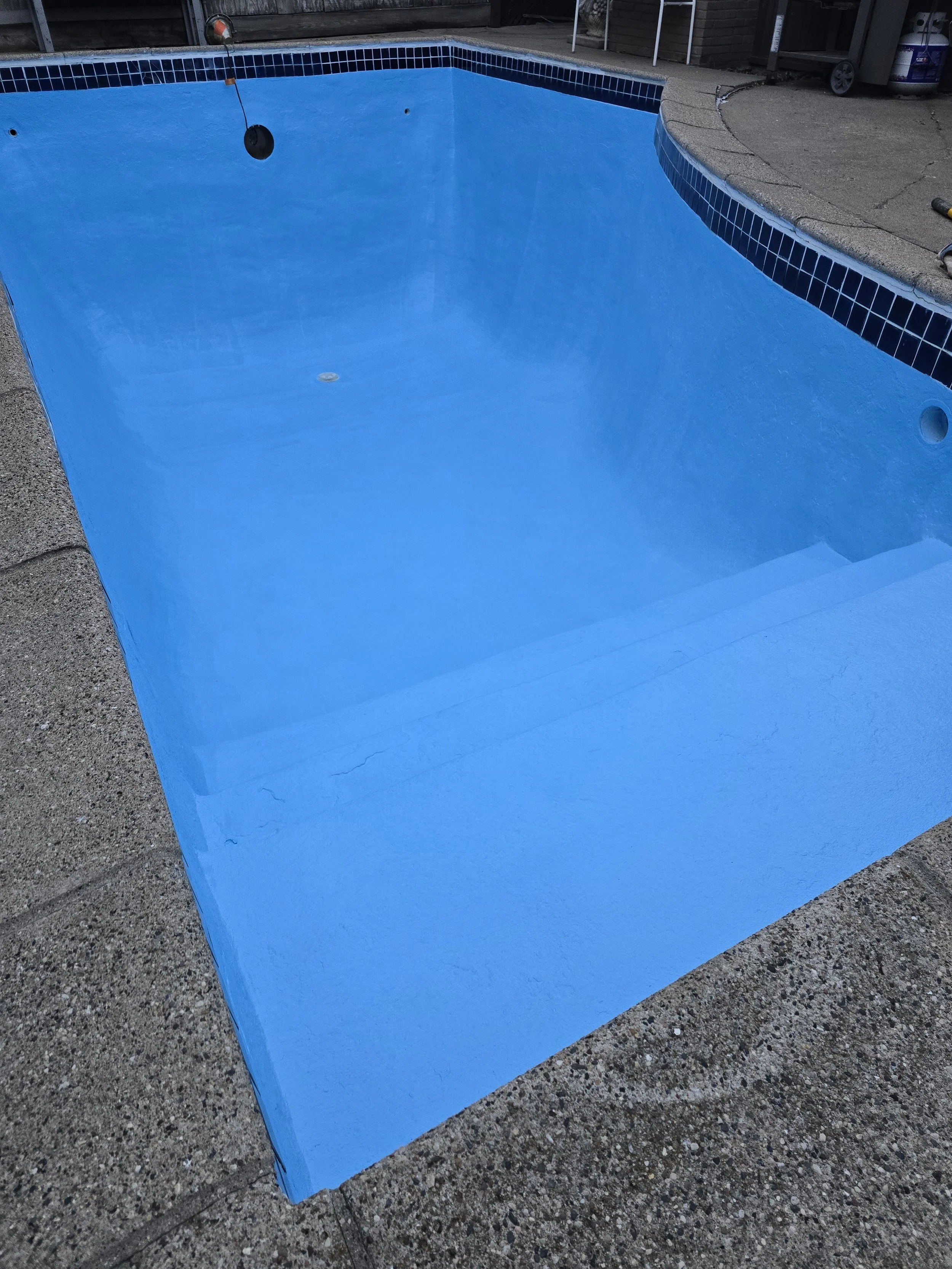 Pool interior after refinishing and recoating at a Lake Harriet property, restoring a clean, durable surface ready for another season.