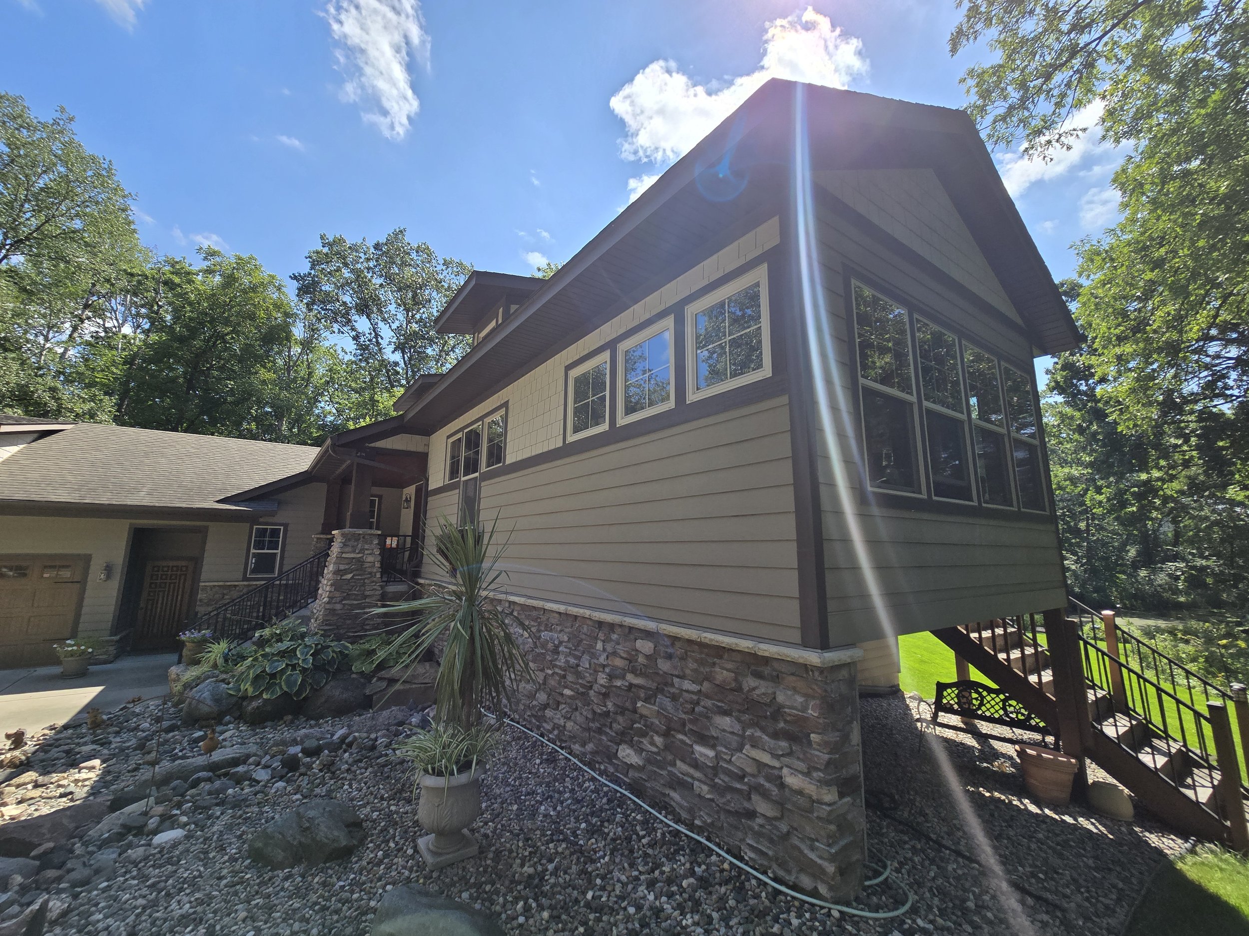 Exterior repaint in Edina highlighting classic Craftsman architecture with rich siding and natural stone details