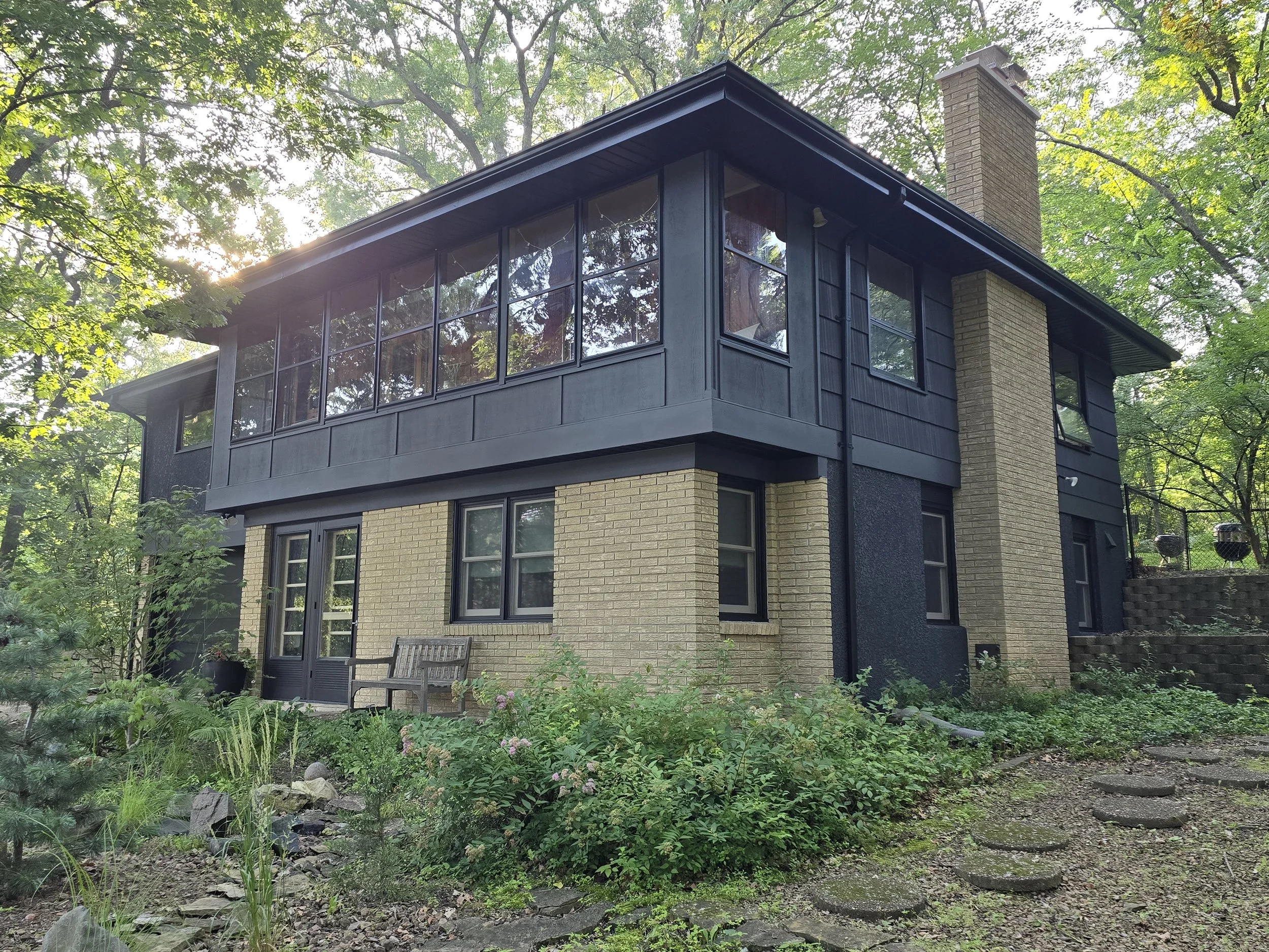 After exterior painting of a modern Minneapolis home featuring a bold dark finish and updated exterior look