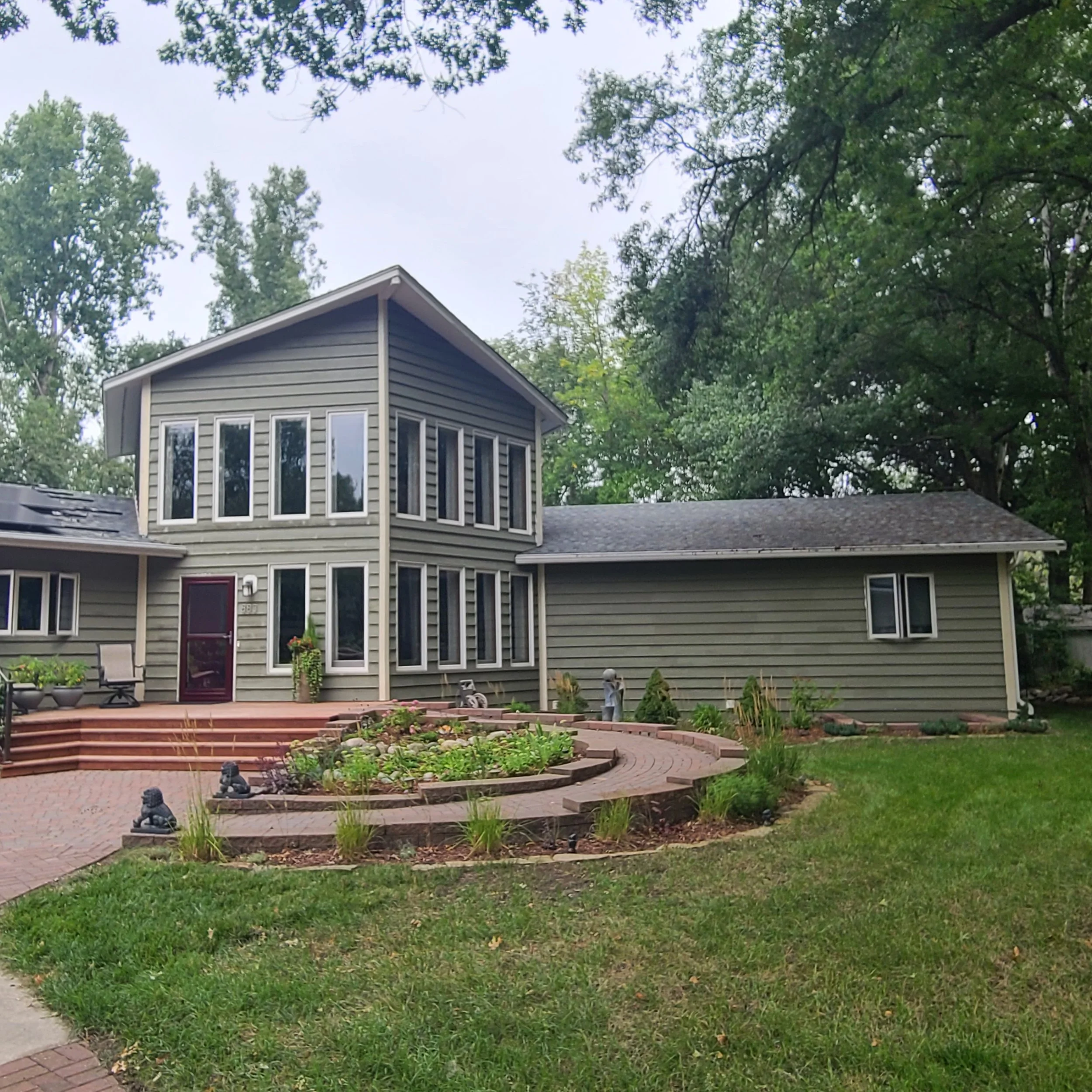 Before exterior painting of a Minneapolis home with dated green siding prior to repaint.