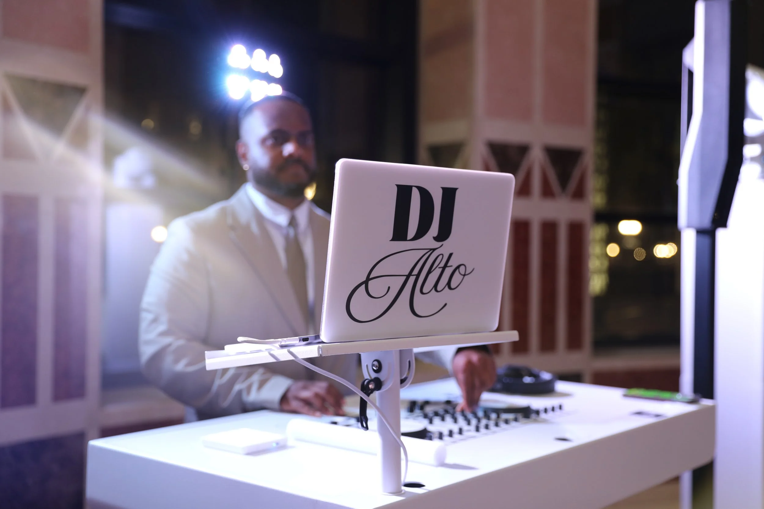 DJ adjusting controls on a professional DJ mixer with turntables.