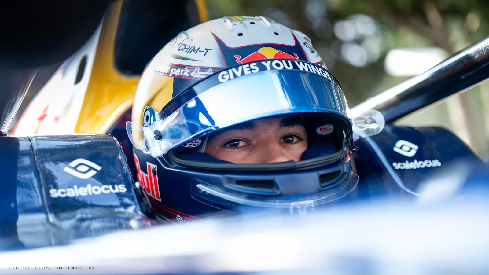 Nikola Tsolov seated in a racing car cockpit with his helmet visor raised.