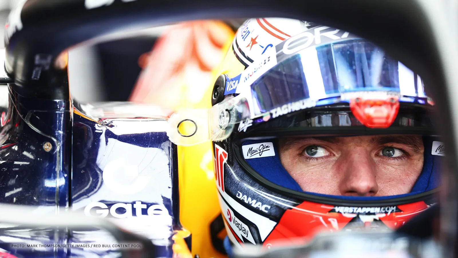 Max Verstappen wearing his helmet in the cockpit of his Red Bull Formula 1 car.