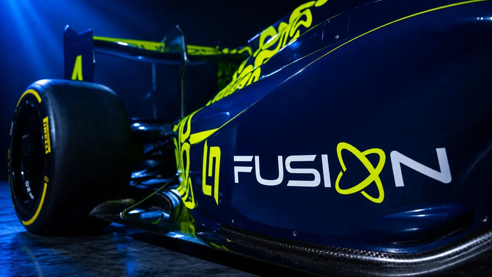 Close-up of LN4 Fusion’s dark-blue launch car, showing the white team name, fluorescent-yellow emblem and rear wheel.