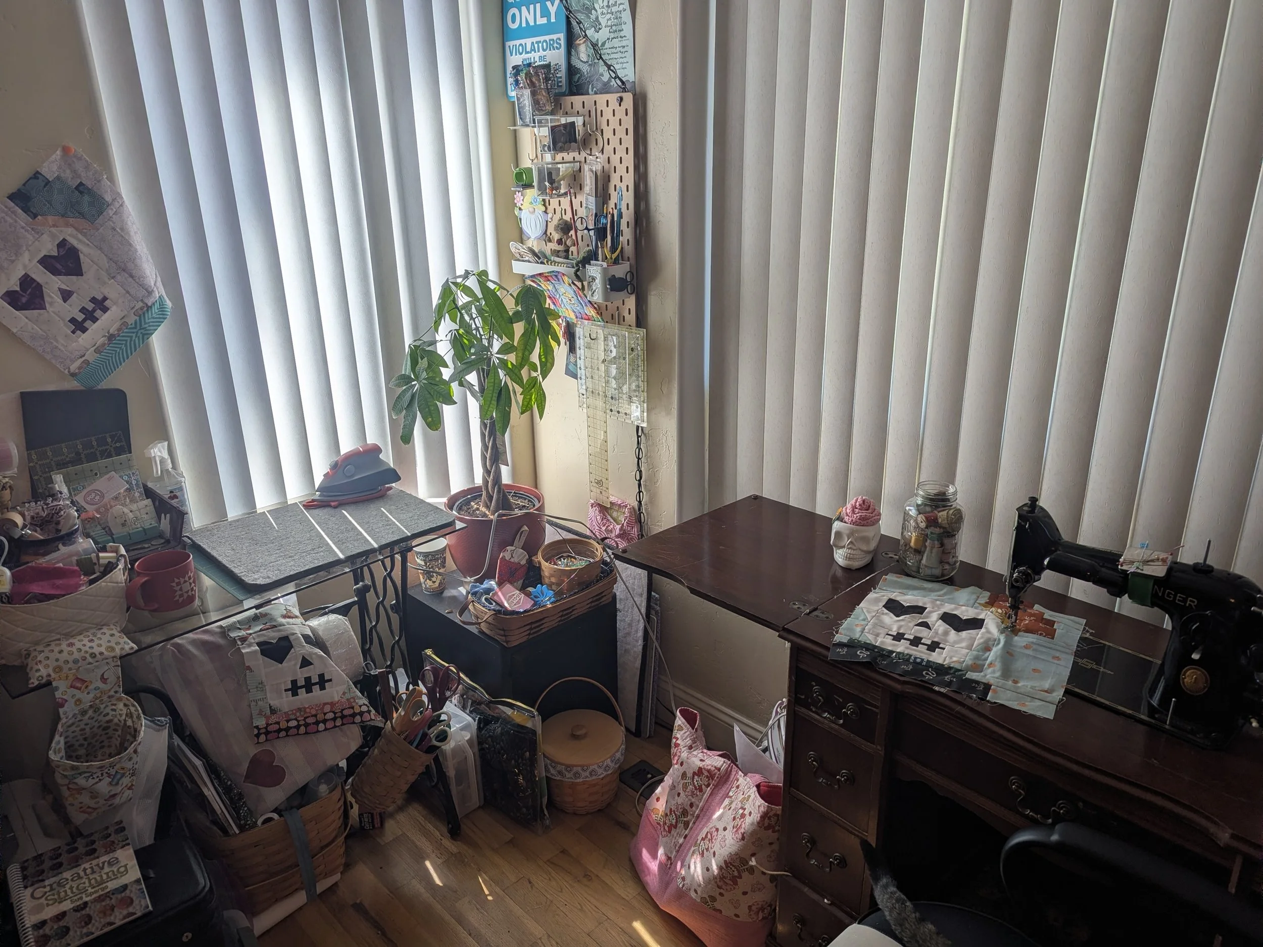 sewing room corner showing pressing station and vintage singer with 3 quilt blocks dispersed through photo