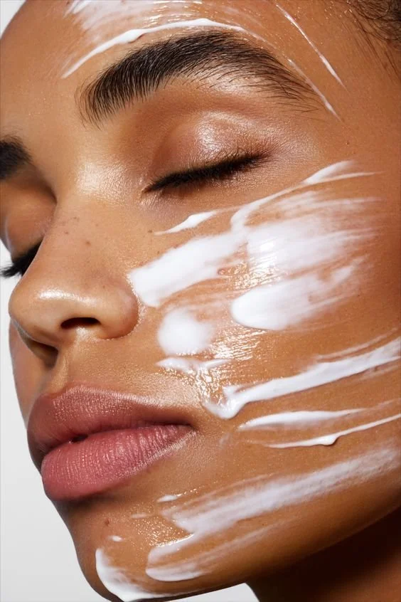 Close-up of a woman's face with lotion applied.