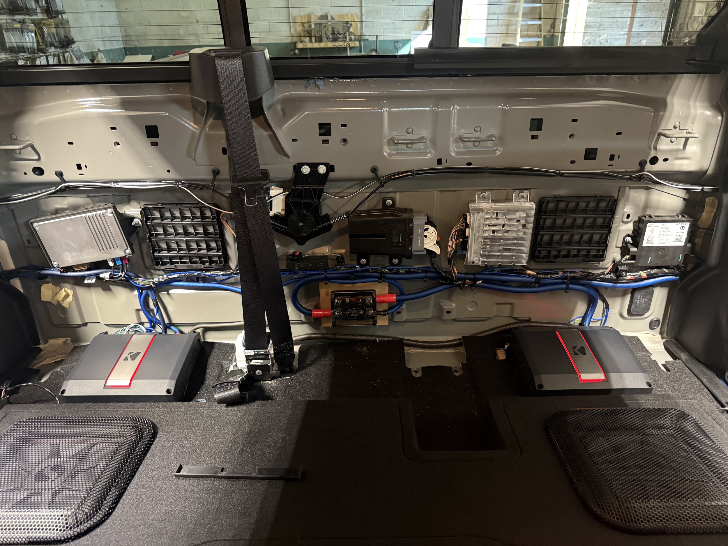 KICKER LX amplifiers and wiring installed behind the rear seat of a 2025 RAM 2500