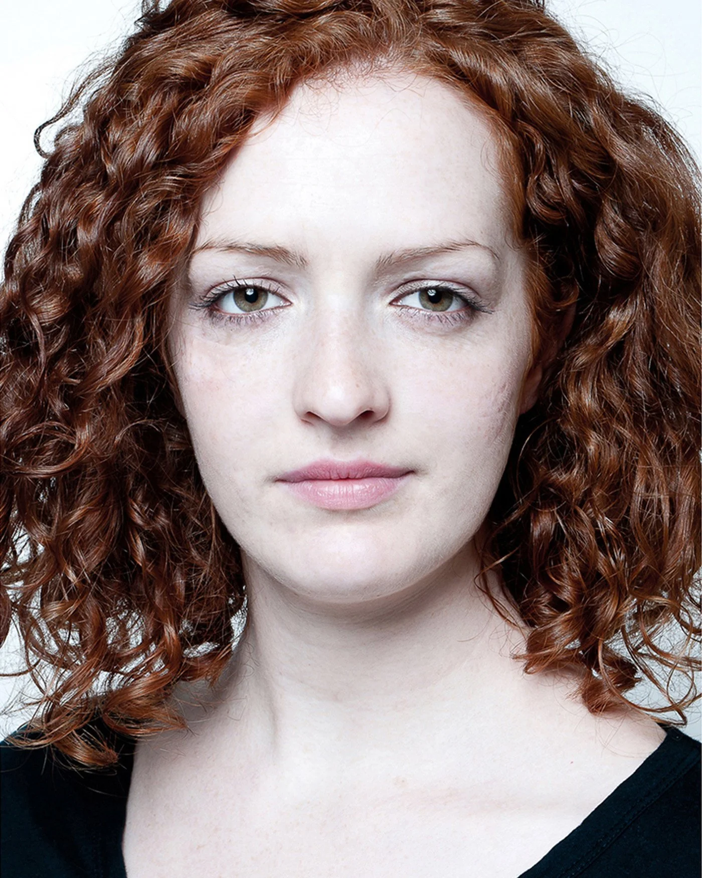 Portrait of a woman with curly red hair.