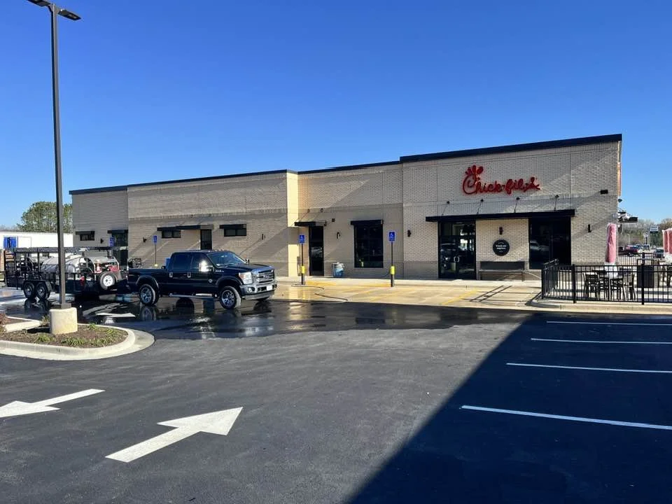 Chick-fil-A restaurant exterior with parking lot and black pickup truck in front.